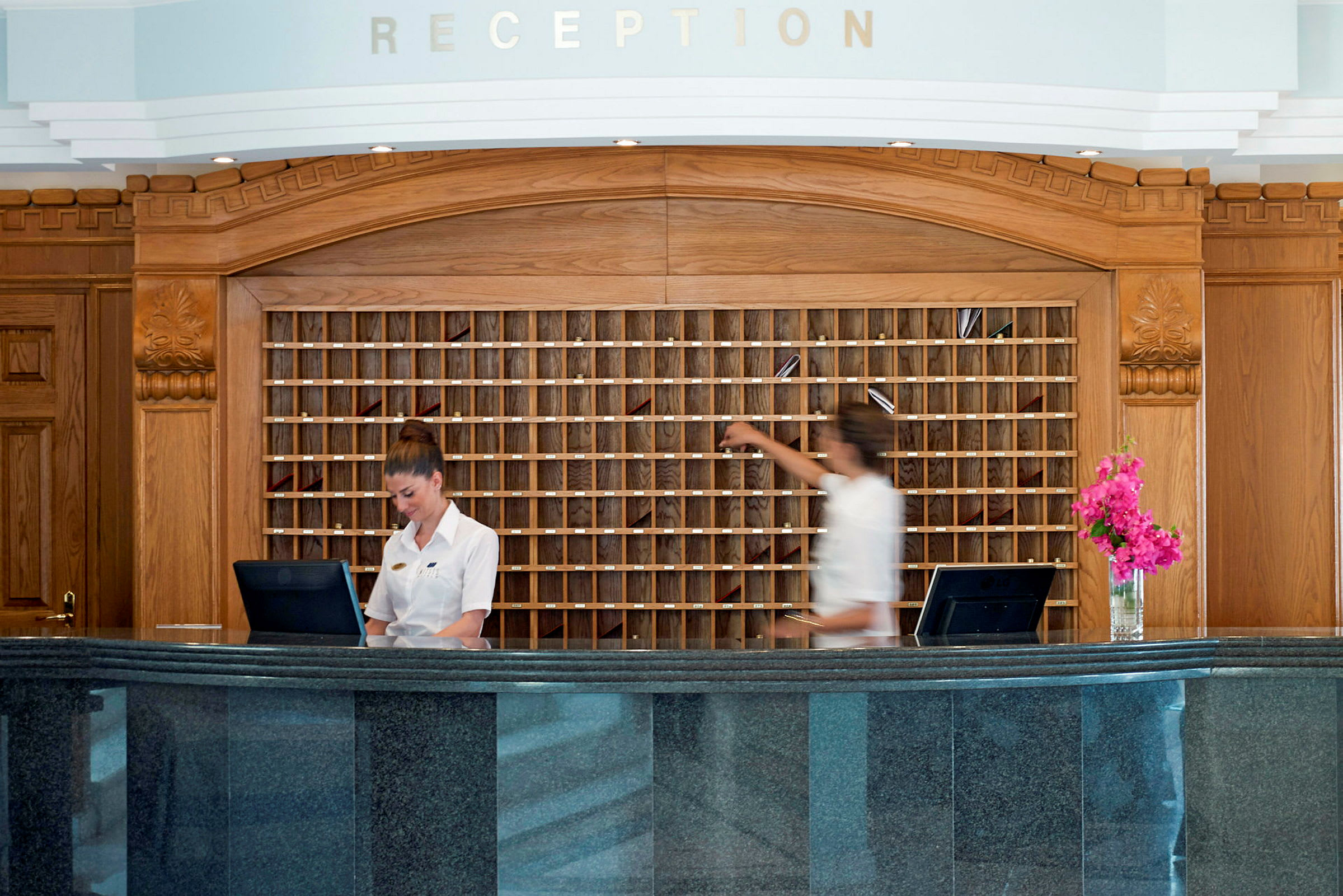 Reception med to diske og træpanel i baggrunden. (AI-genereret tekst)