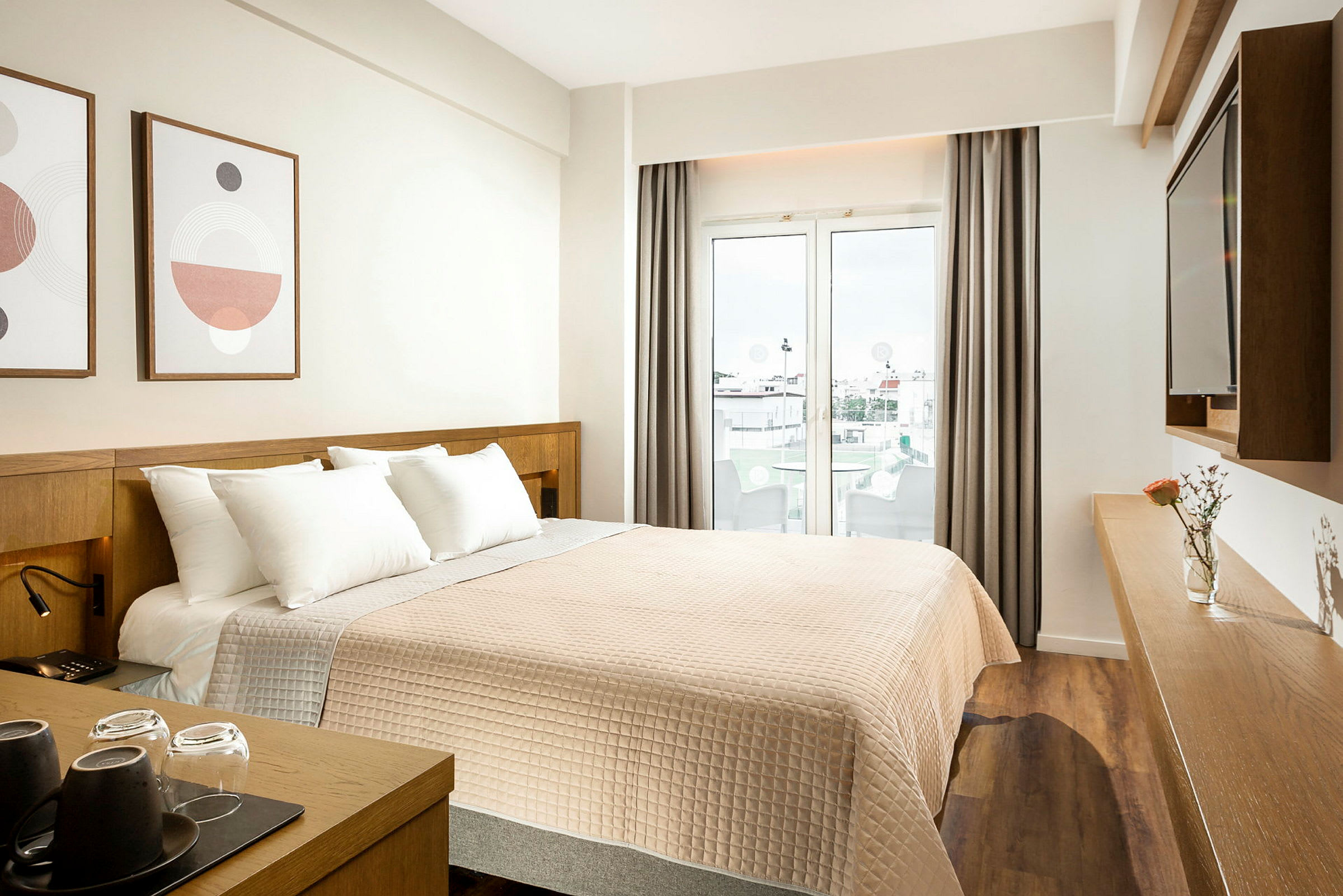 Hotelværelse med en dobbeltseng, dekoration på væggen og en glasdør, der fører ud til en balkon. (AI-genereret tekst)