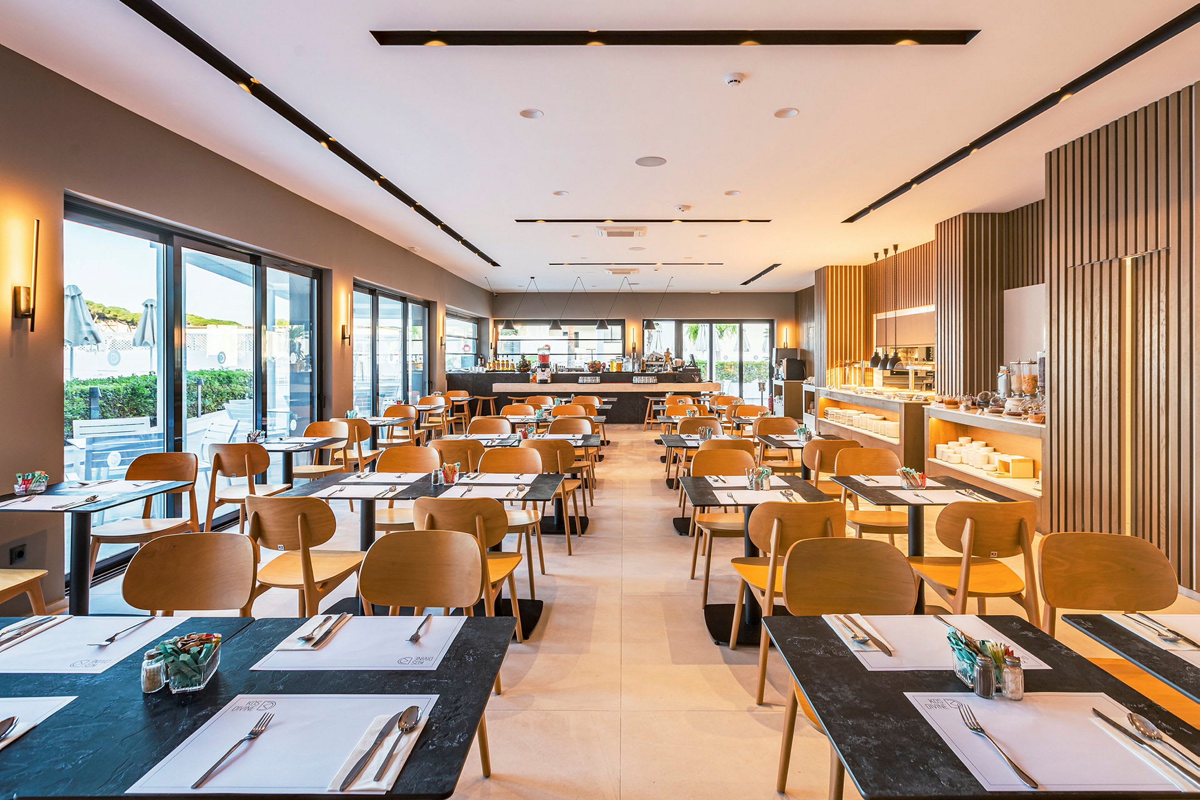 En lys restaurant med moderne møbler og dækkede borde. (AI-genereret tekst)