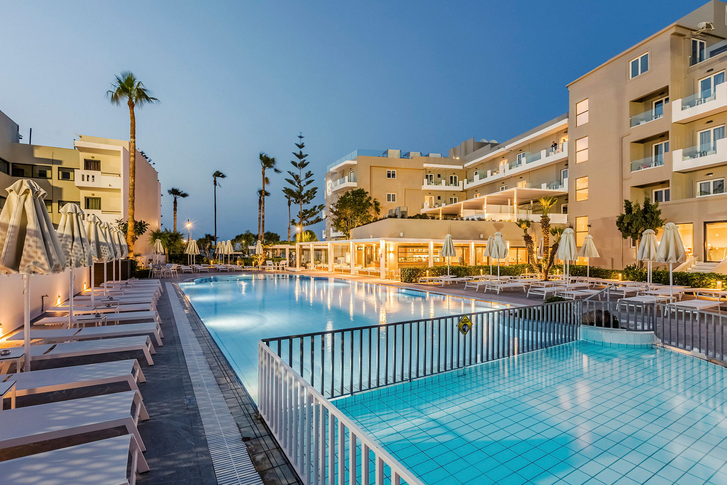 Udendørs pool med solsenge ved et hotel. (AI-genereret tekst)