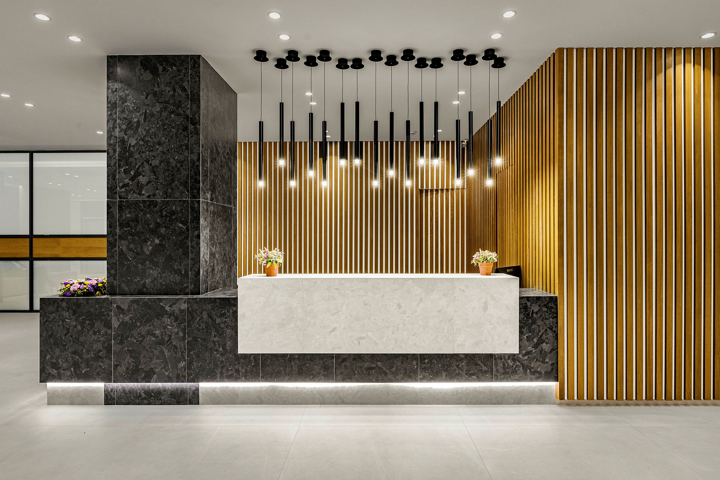 Reception med moderne design, marmorytoverflade og lodrette træpaneler. (AI-genereret tekst)