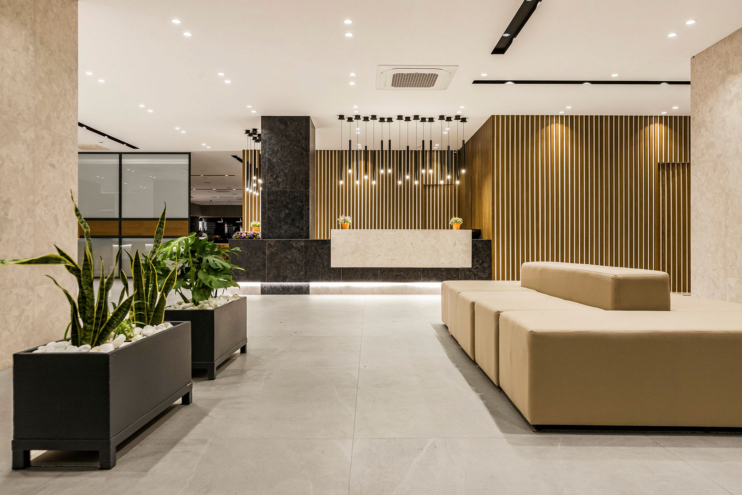 Moderne hotelreception med komfortable siddepladser og planteudsmykning. (AI-genereret tekst)
