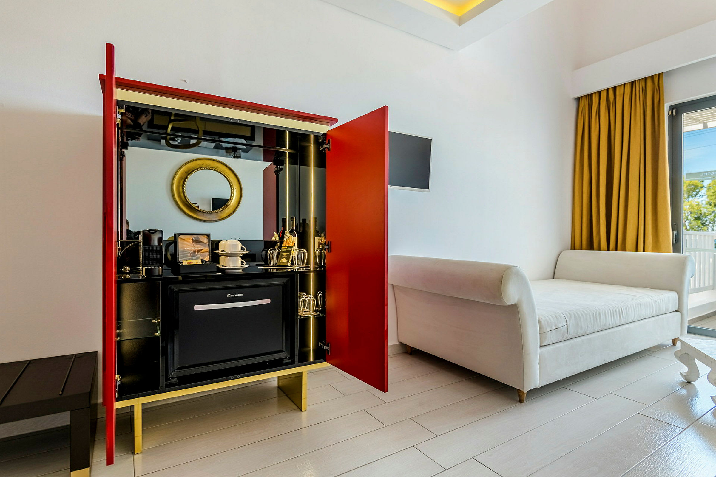 Hotelværelse med en siddemøbel, garderobe og minibar. (AI-genereret tekst)