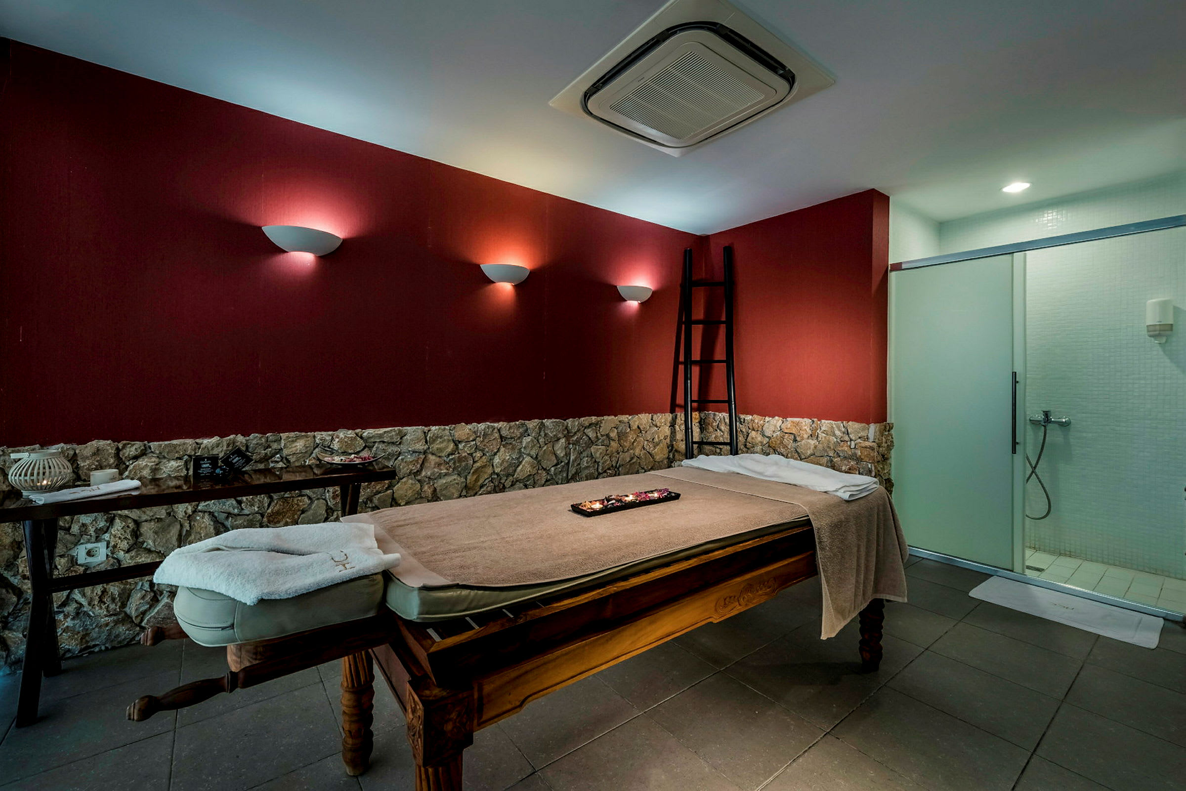 En massageseng i et rum med røde vægge og stenpanel. (AI-genereret tekst)