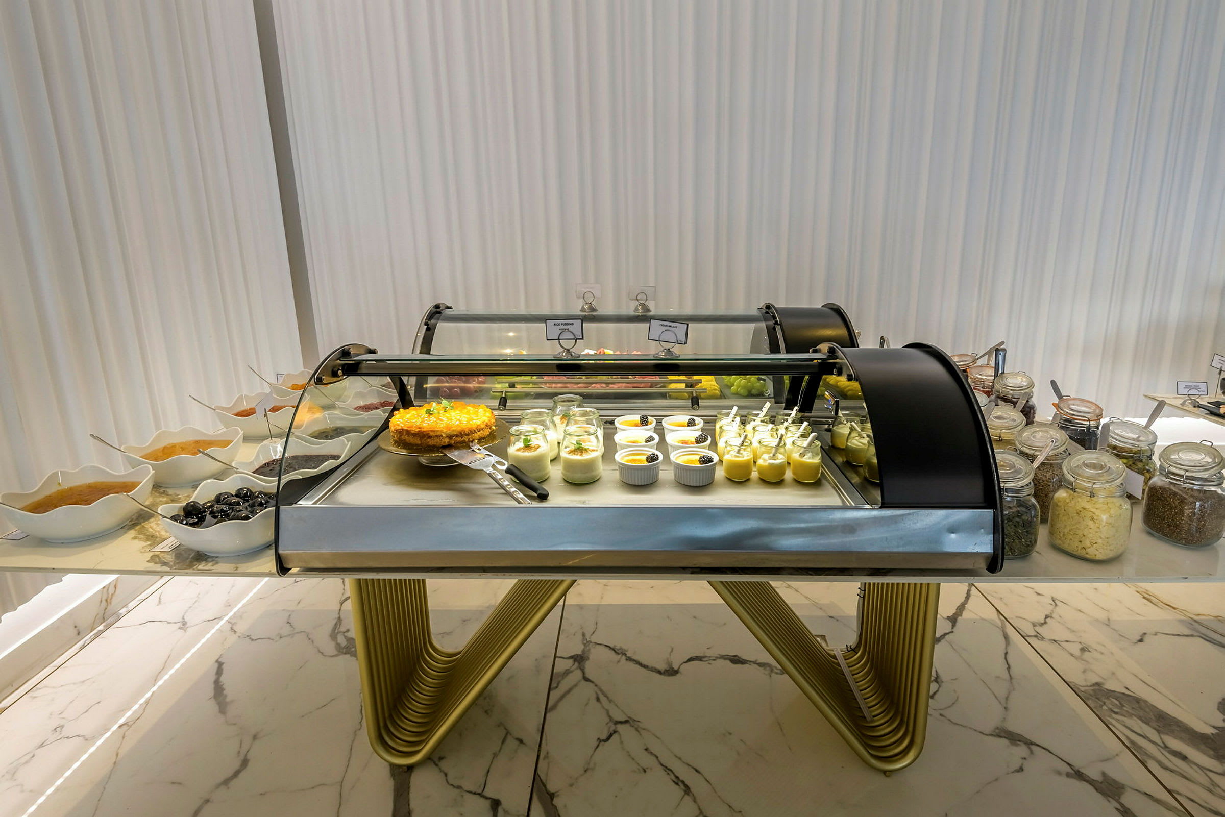 En buffetdisk med desserter, inklusive glas og skåle med forskellige desserter. (AI-genereret tekst)