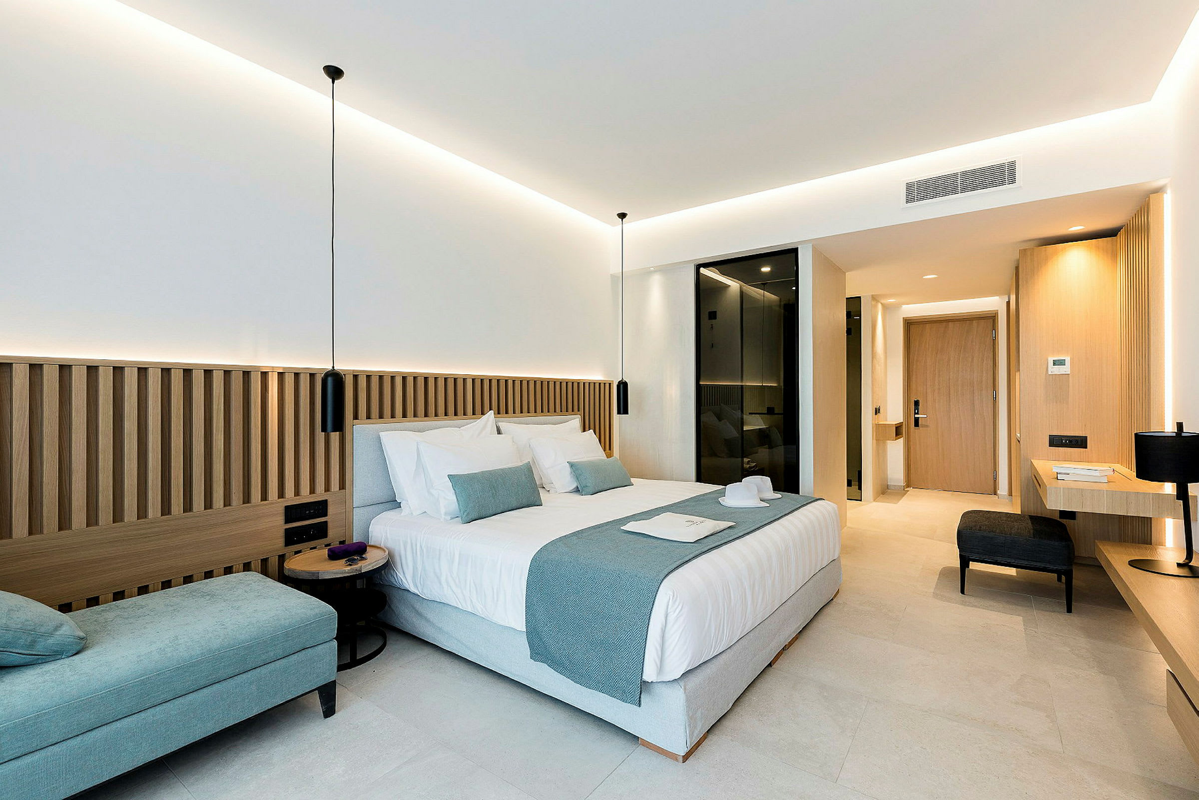 Moderne designet hotelværelse med dobbeltseng, siddeplads og skrivebord. (AI-genereret tekst)