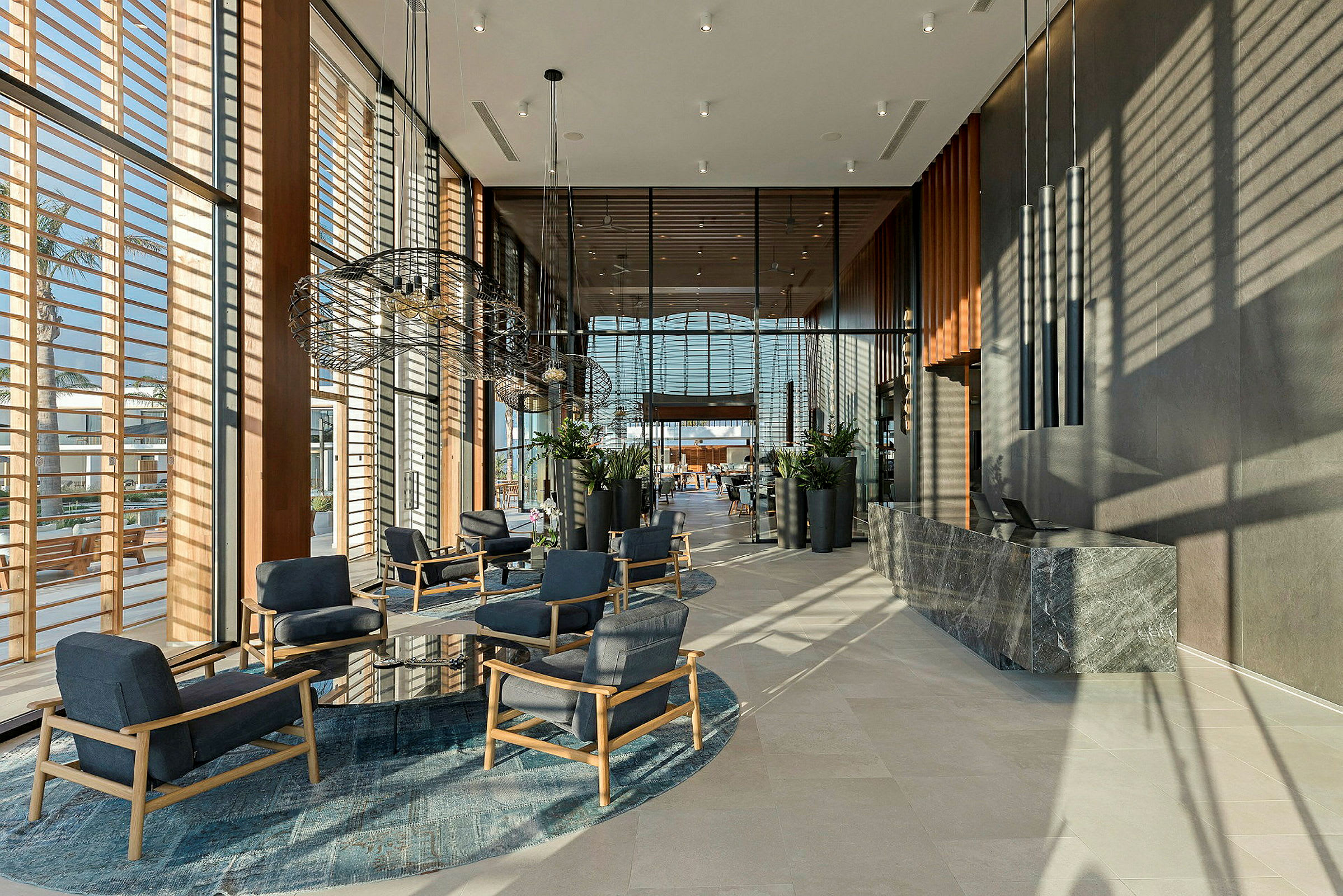 Hotellobby med moderne møbler og store vinduer. (AI-genereret tekst)