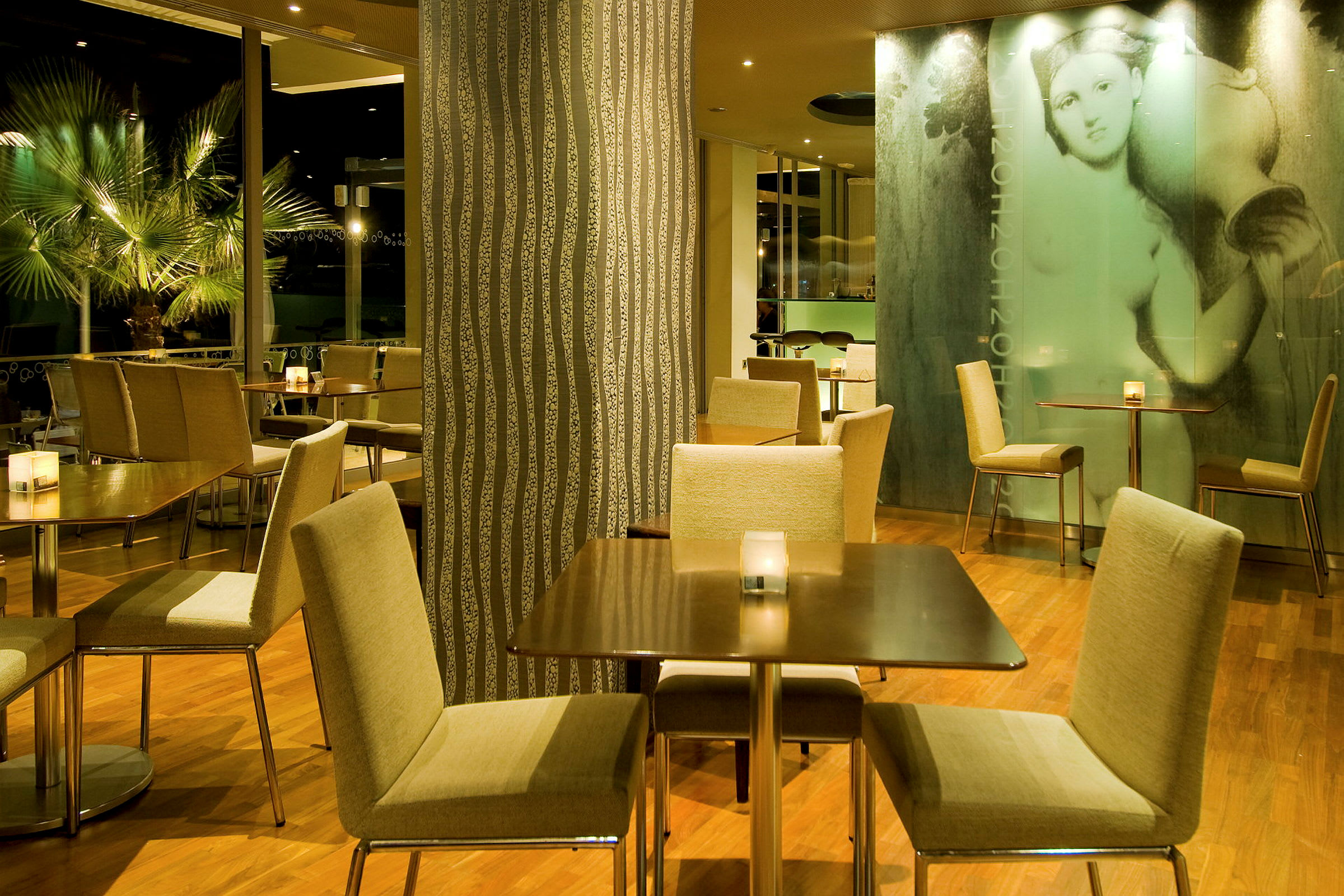 En restaurantinteriør med borde og stole på et trægulv, omgivet af dekorative vægge og planter. (AI-genereret tekst)