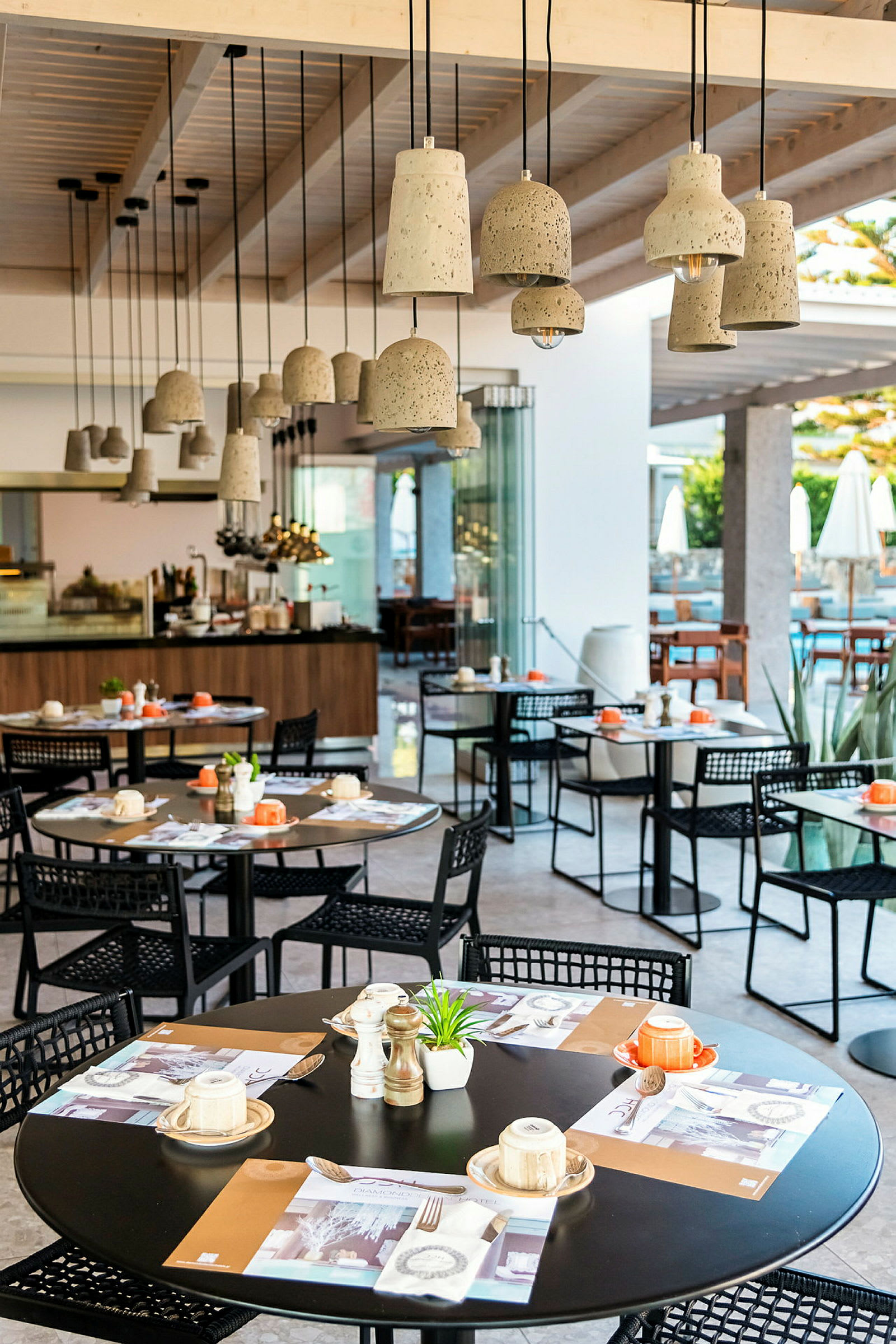 Restaurant med moderne hængende lamper og borde dækket til måltider. (AI-genereret tekst)