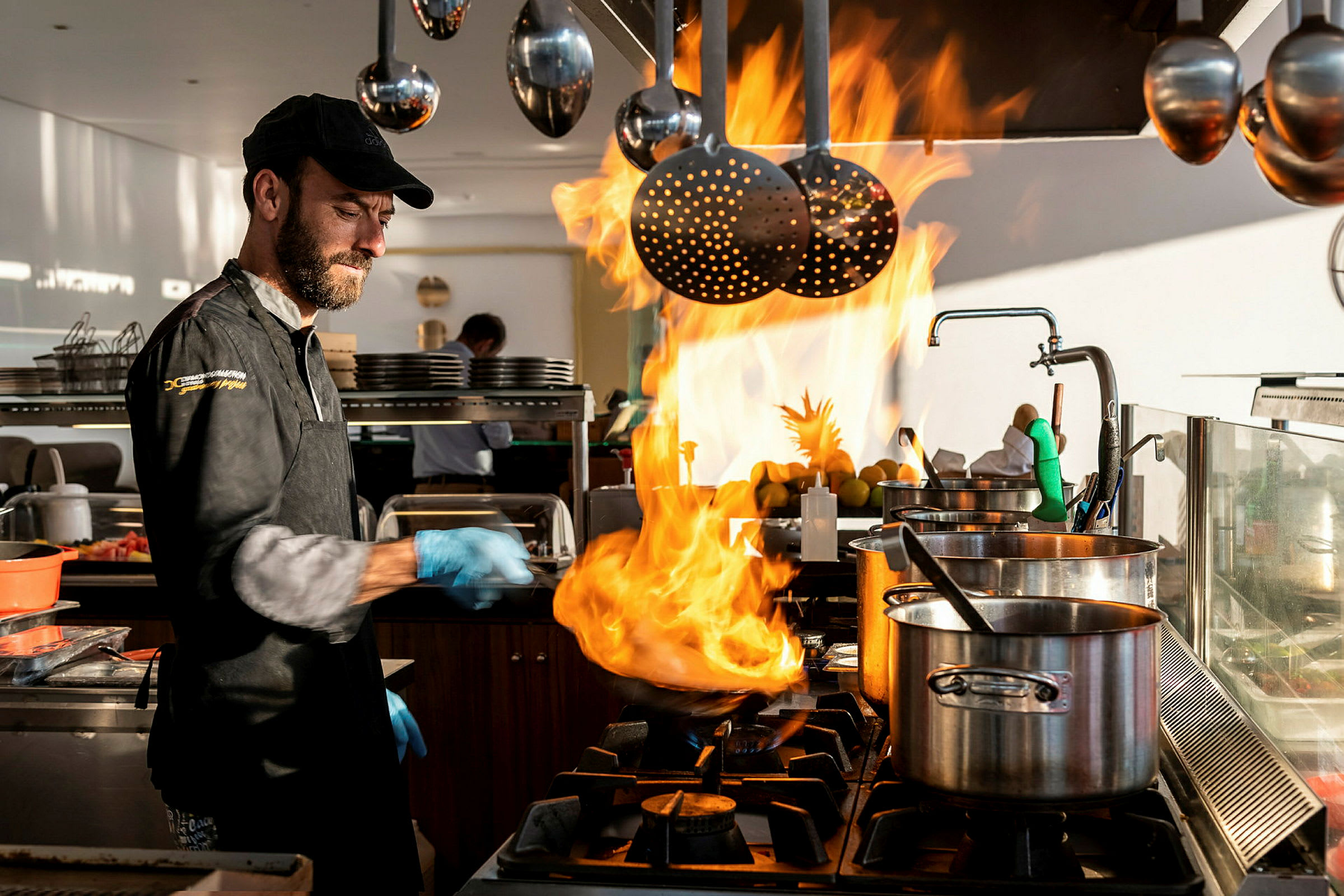 En kok tilbereder mad på en komfur med flammer. (AI-genereret tekst)