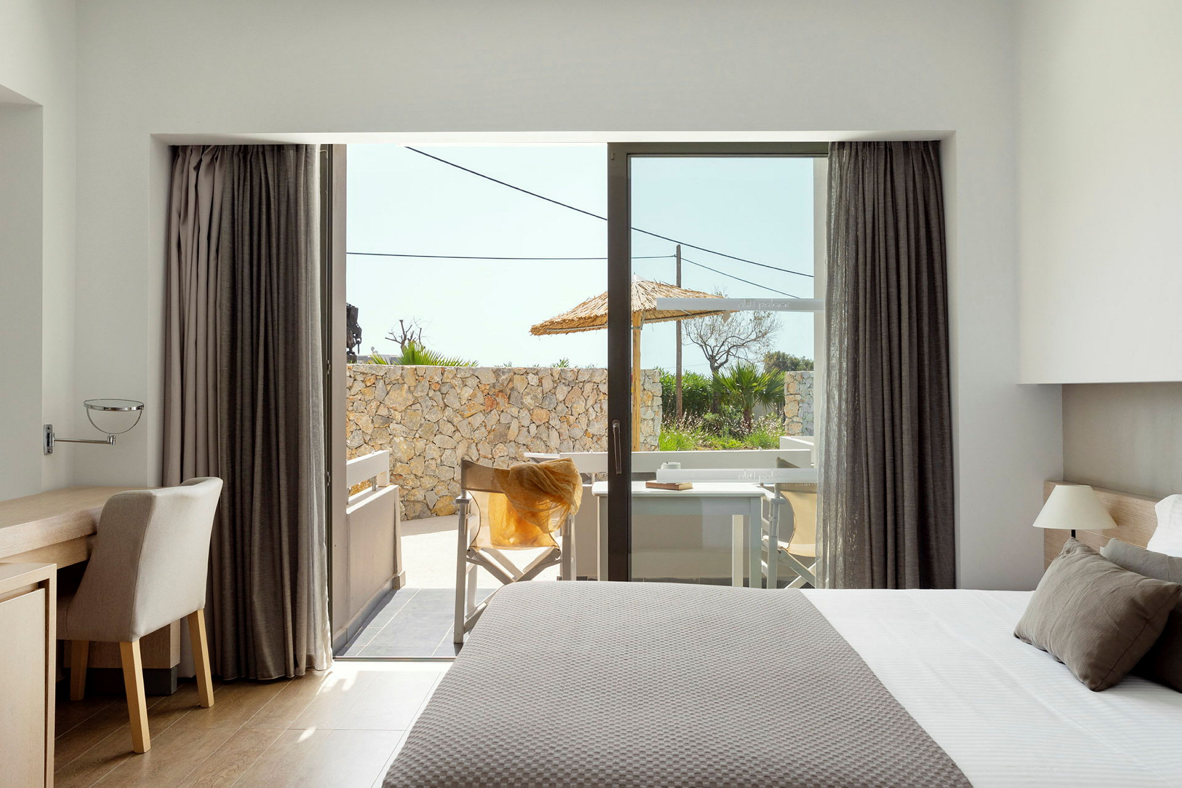 Moderne hotelværelse med udsigt til en terrasse. (AI-genereret tekst)