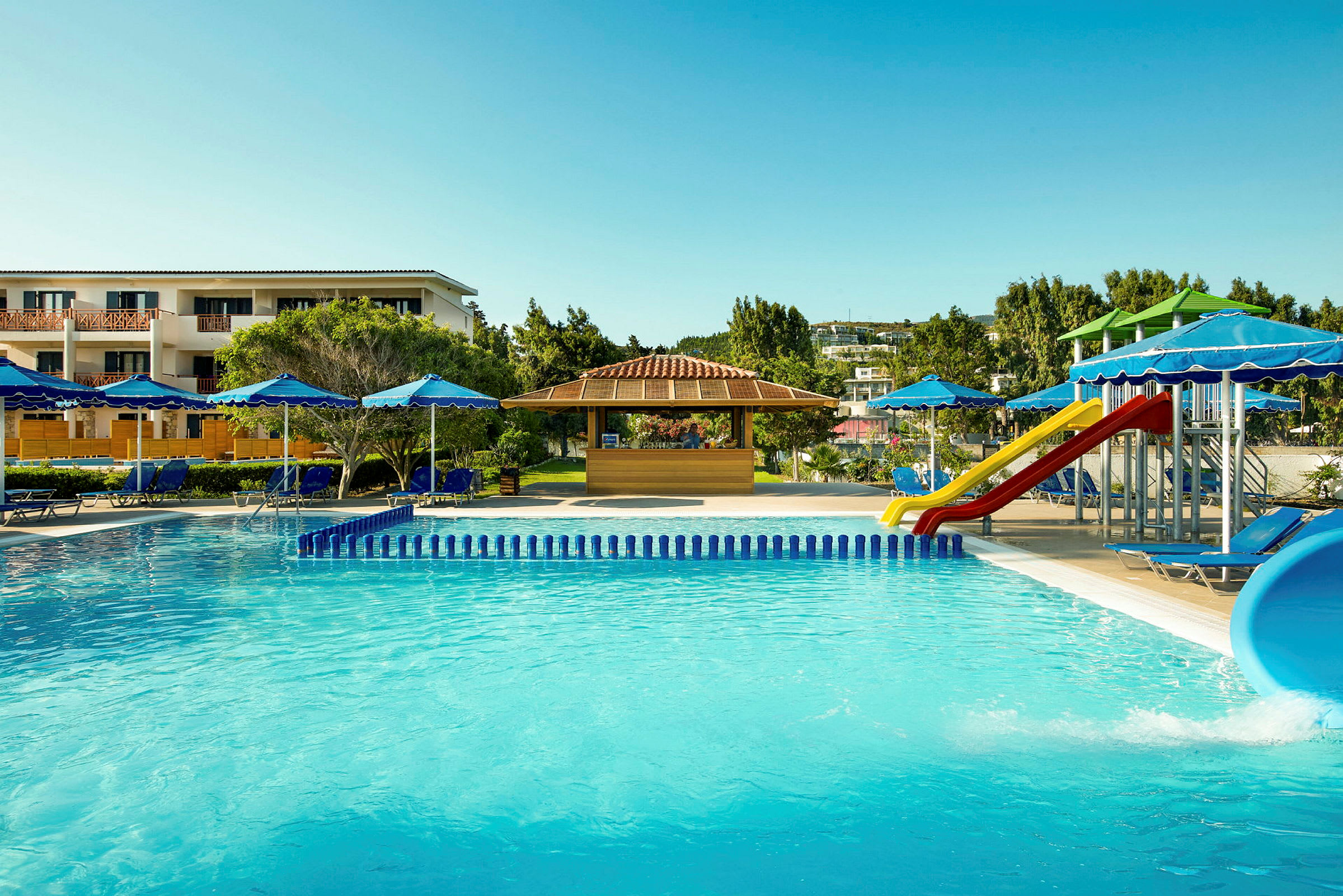 Billede af en hotelpool, liggestole med parasoller og en legeplads med rutsjebaner. (AI-genereret tekst)