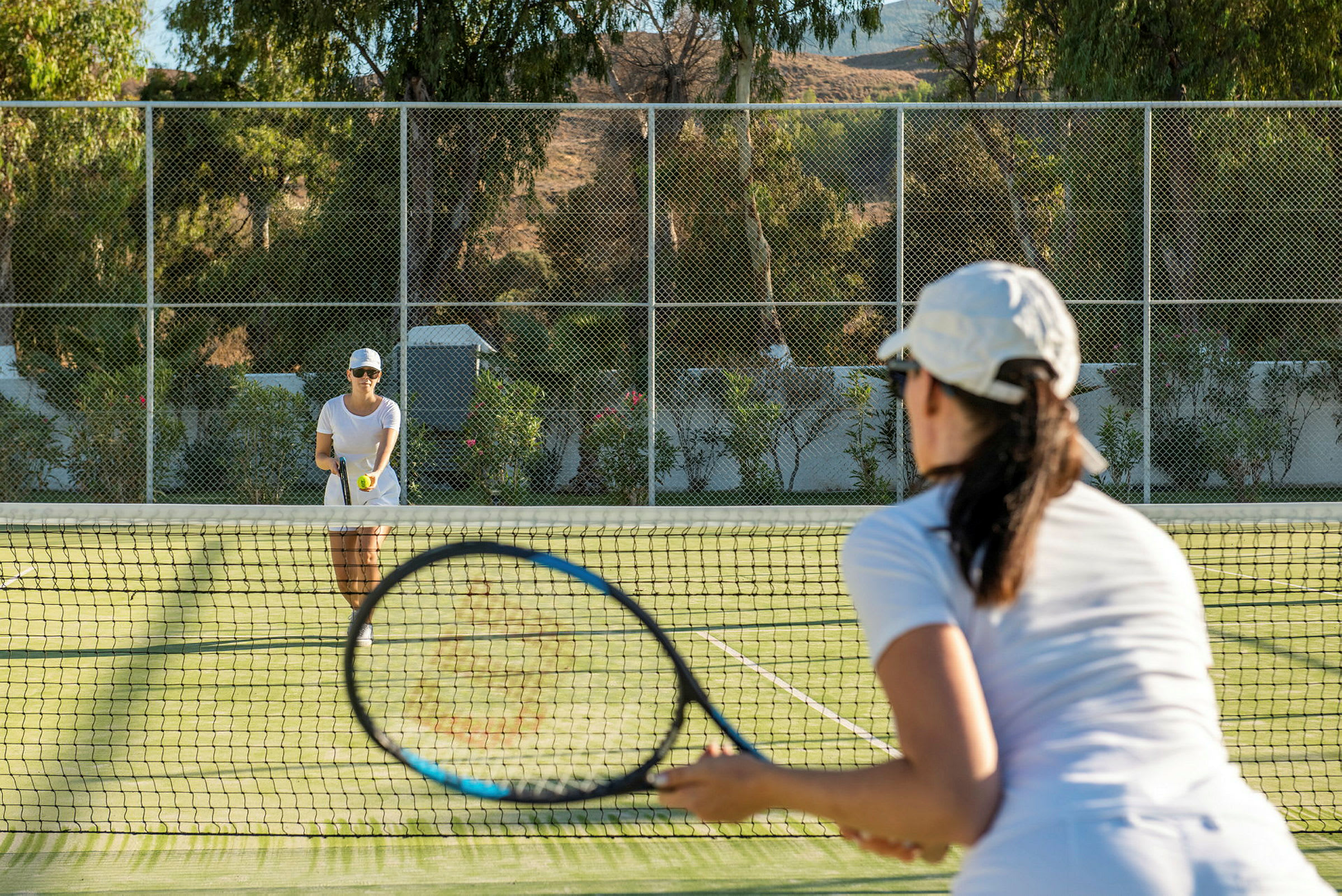 To personer spiller tennis på en græsbane. (AI-genereret tekst)