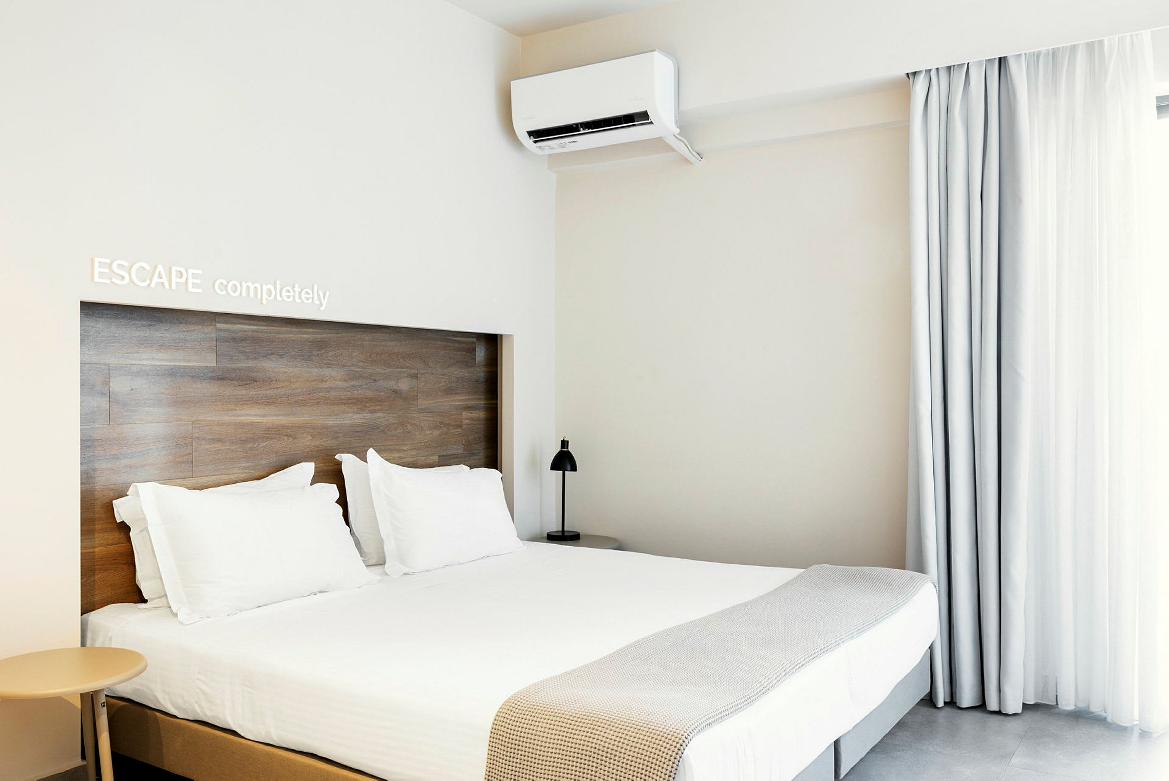 Et moderne hotelværelse med dobbeltseng, lys indretning og aircondition. (AI-genereret tekst)