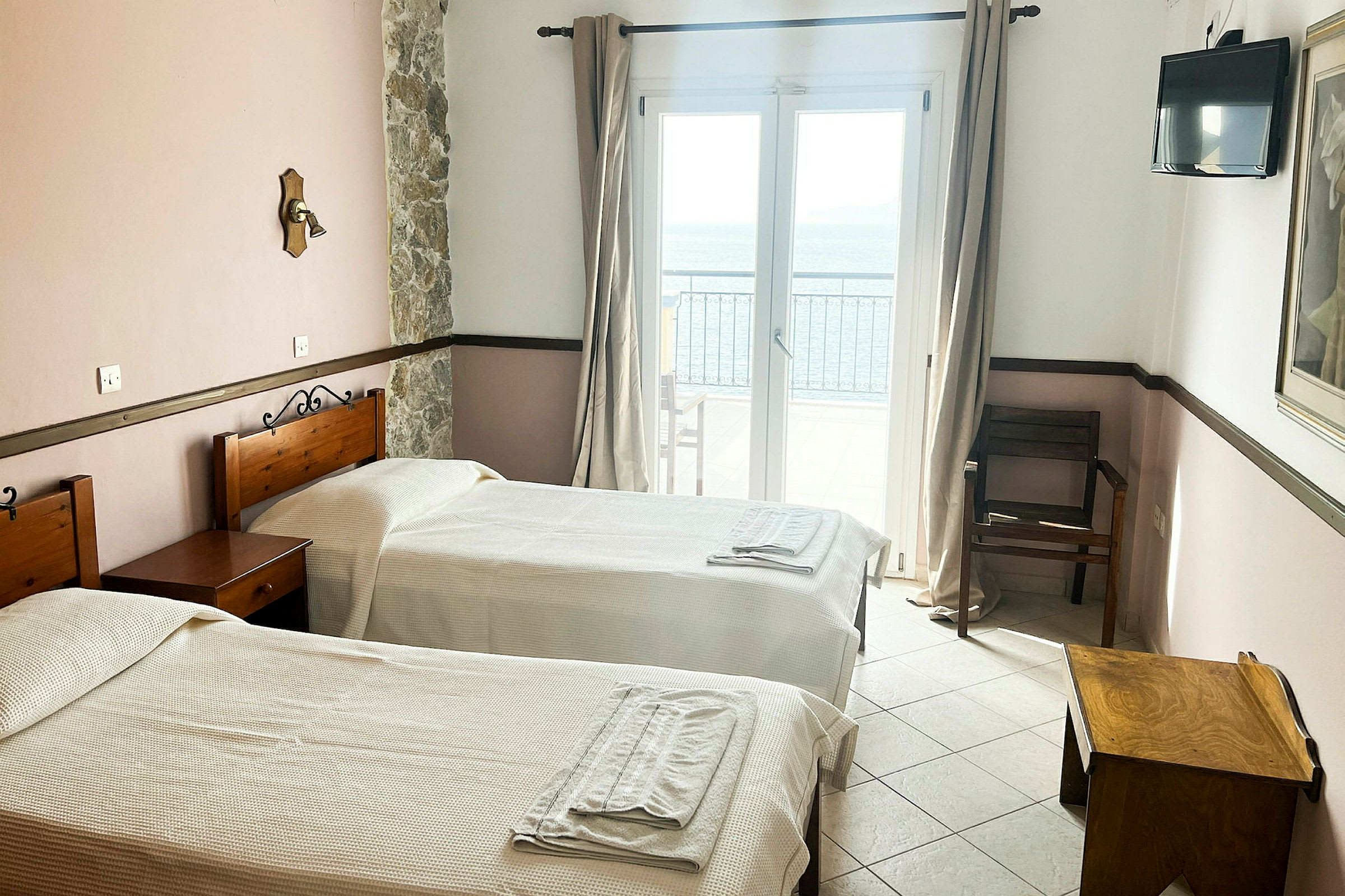 Hotelværelse med to enkeltsenge, et vindue med havudsigt. (AI-genereret tekst)