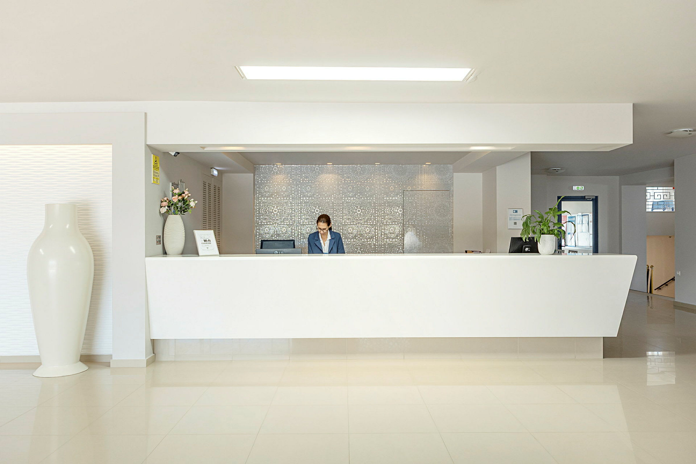 Hotelreception med hvid skranke og moderne indretning. (AI-genereret tekst)