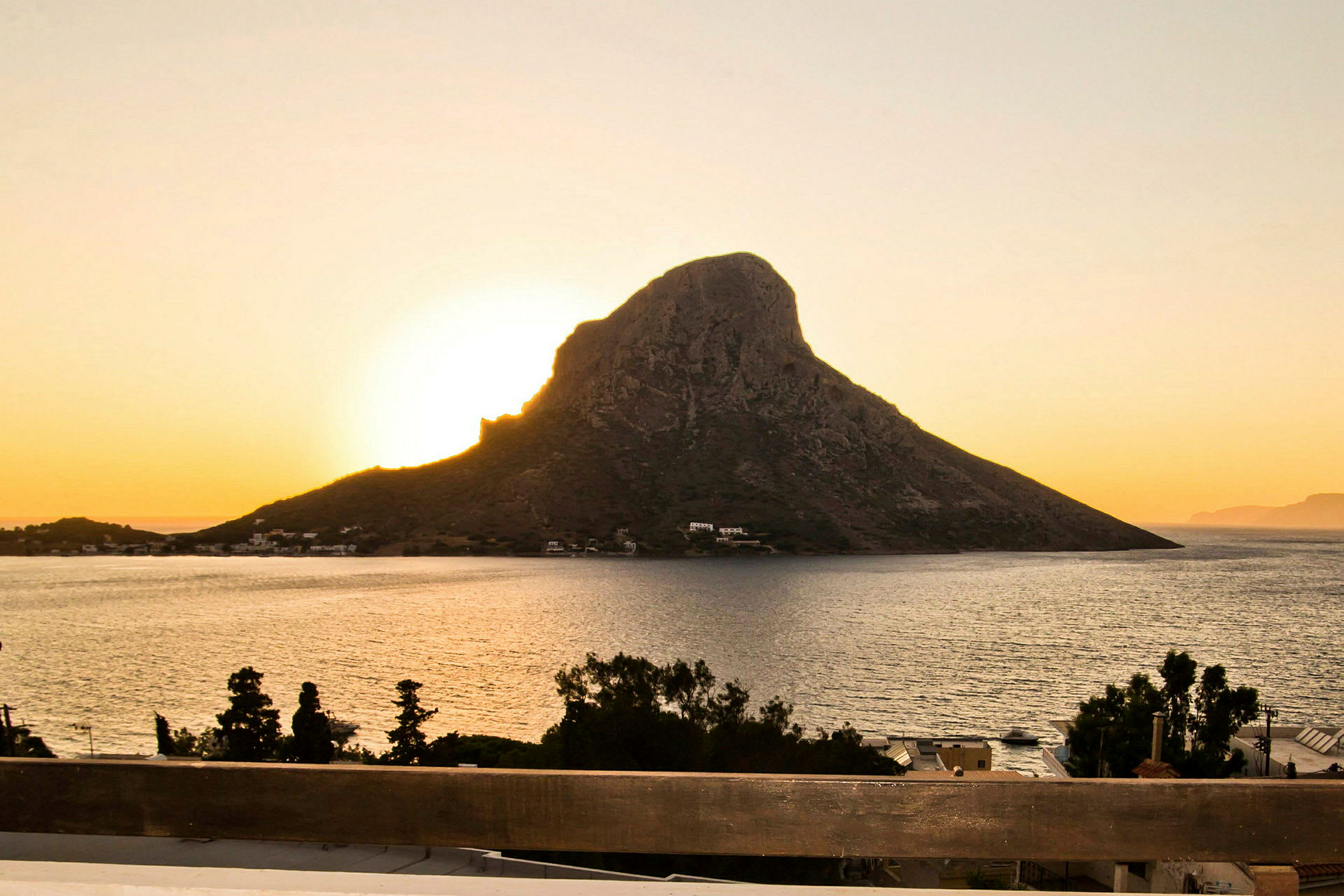 Solnedgang bag en klippe ved havet. (AI-genereret tekst)
