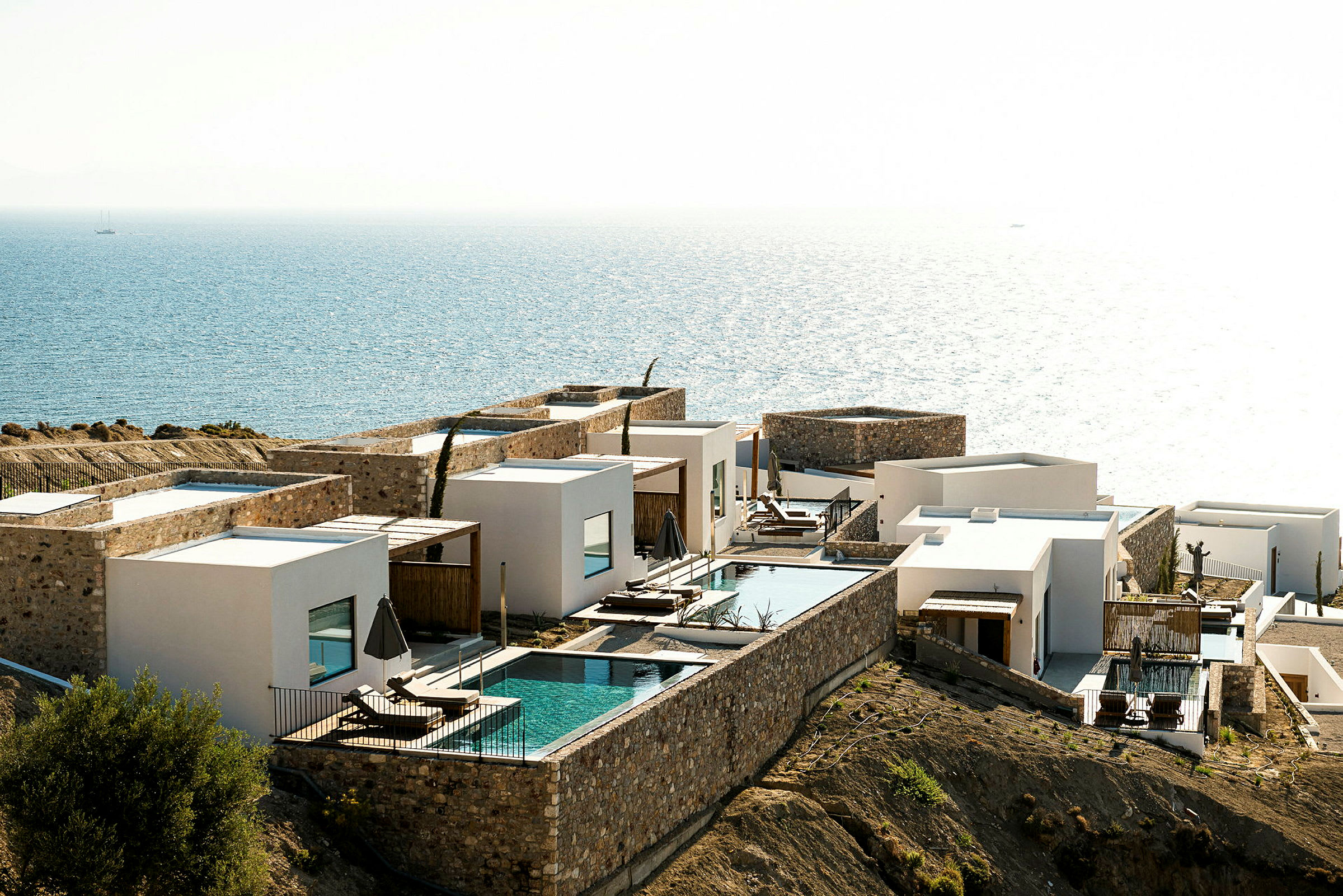 Hvide huse med private pools ved havet. (AI-genereret tekst)