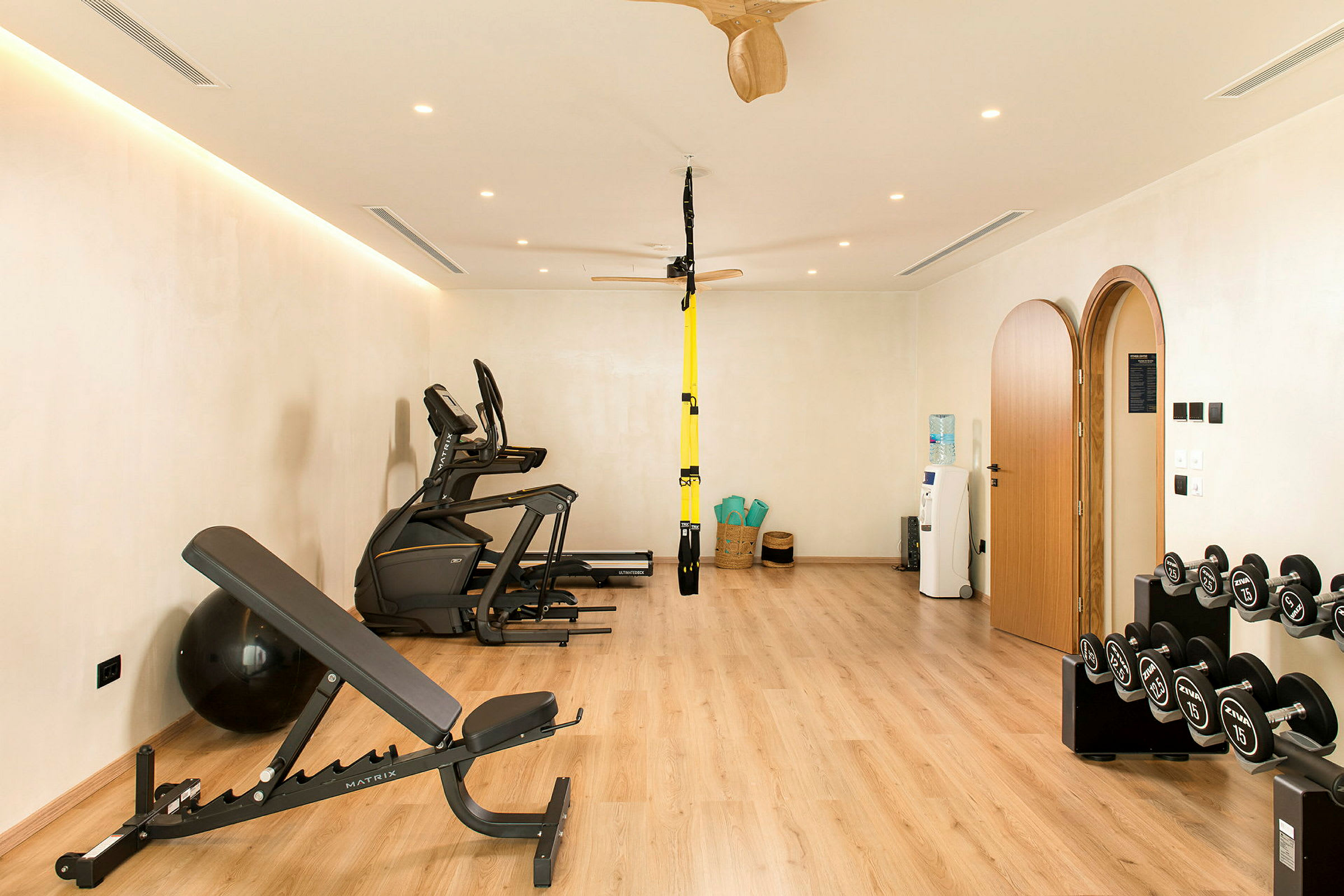 Et fitnesscenter med træningsmaskiner, håndvægte og yogamåtter. (AI-genereret tekst)