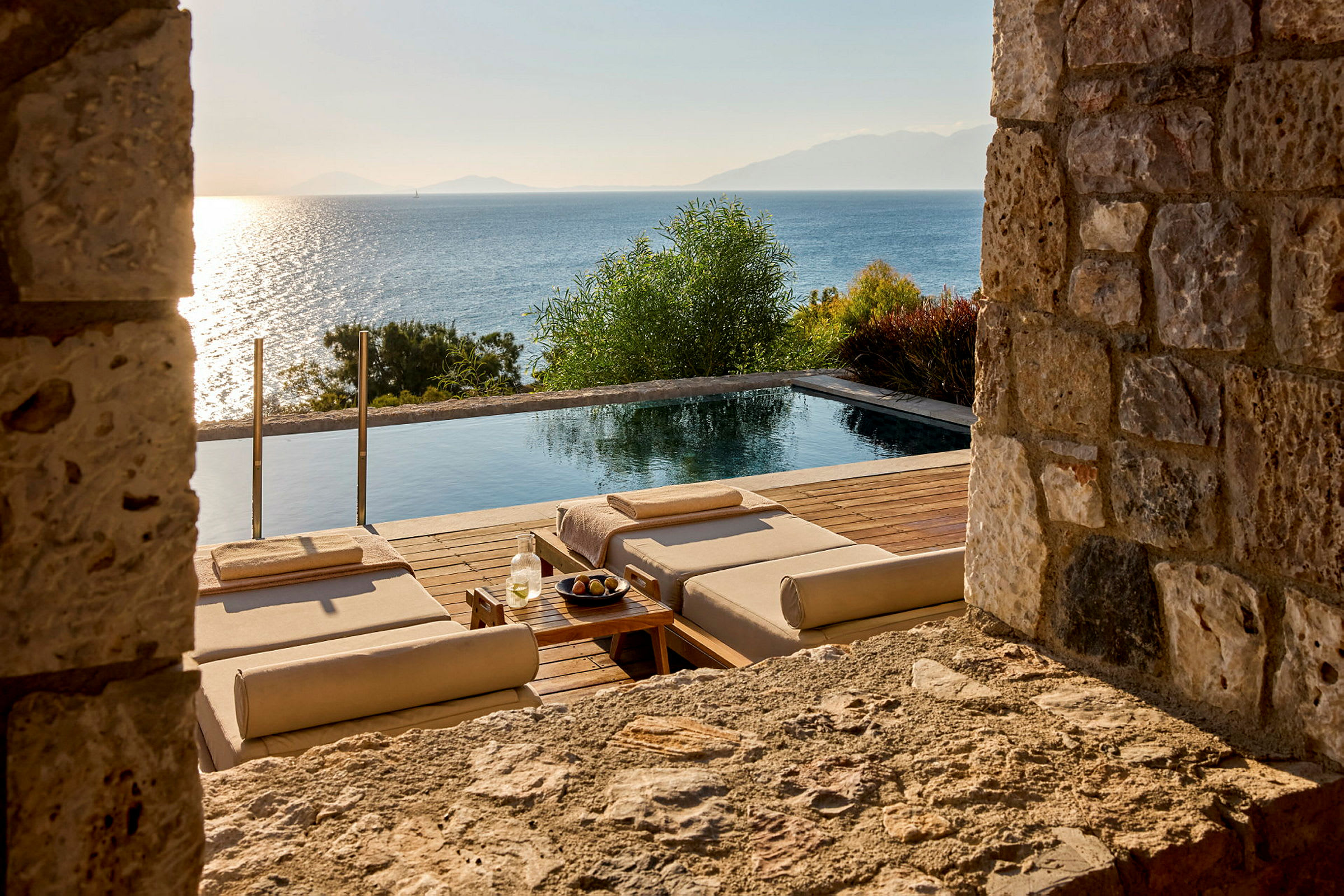 En infinity-pool med liggestole har udsigt over havet. (AI-genereret tekst)