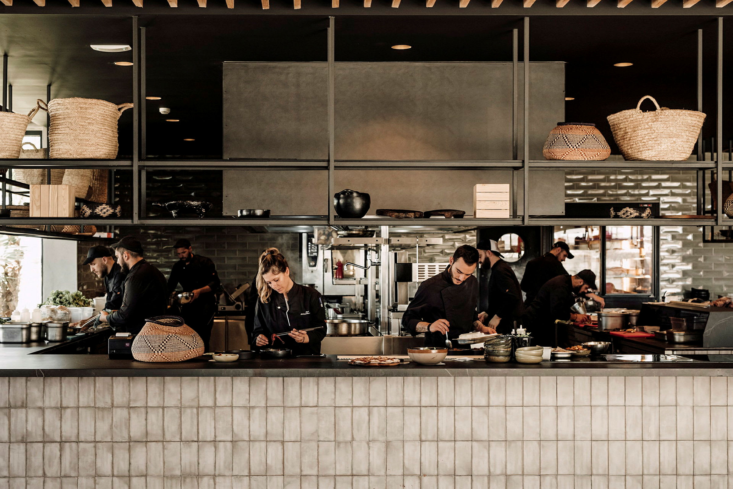 En restaurantkøkkeninteriør med kokke, der forbereder mad. (AI-genereret tekst)