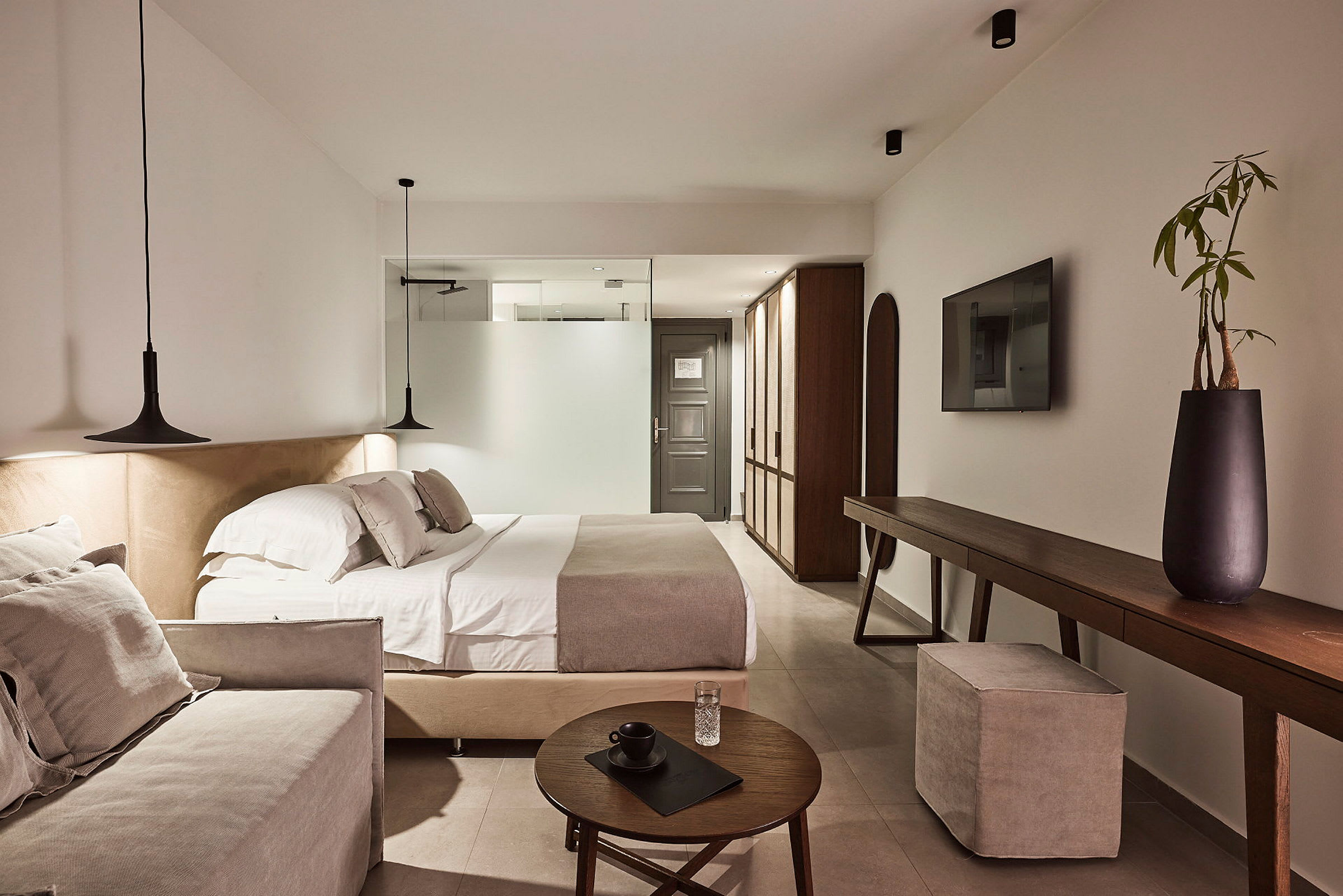 Et moderne hotelværelse med dobbeltseng, sofa og elegant indretning. (AI-genereret tekst)