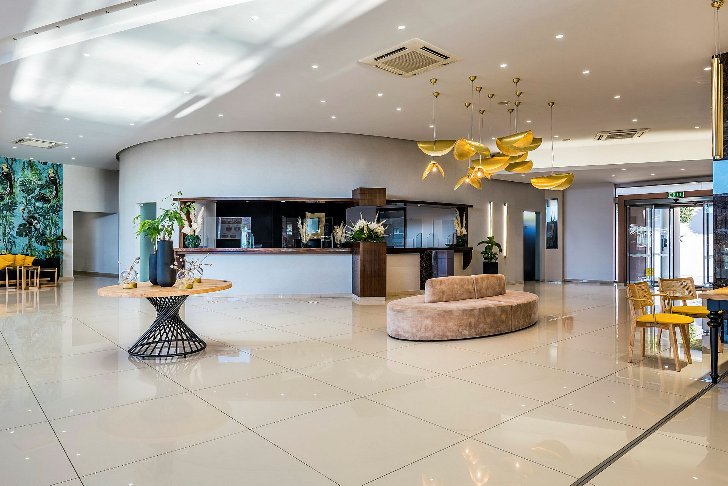 Lys hotellets lobby med moderne indretning, sofaer og borde. (AI-genereret tekst)