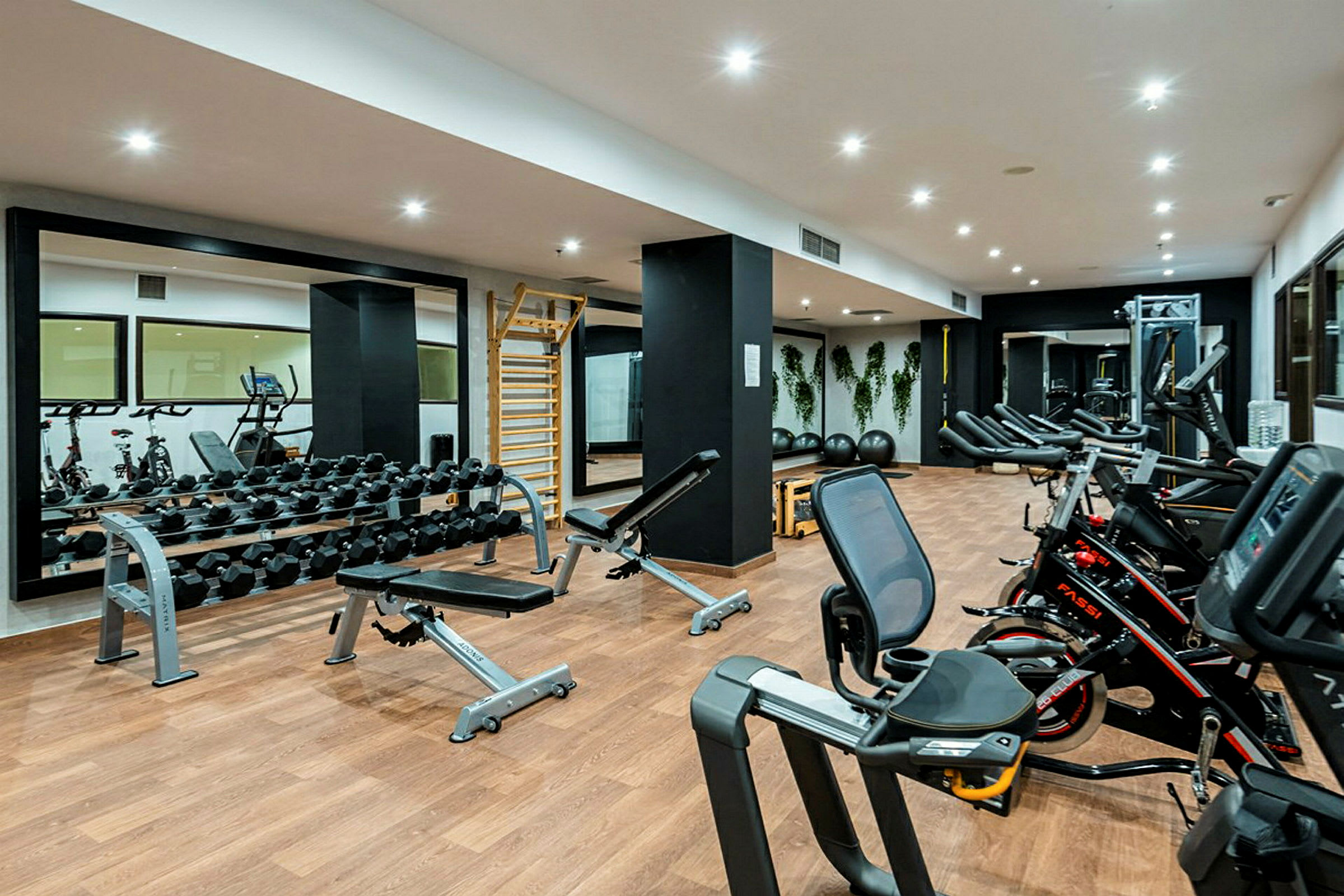 Et fitnesscenter med træningsmaskiner og håndvægte. (AI-genereret tekst)