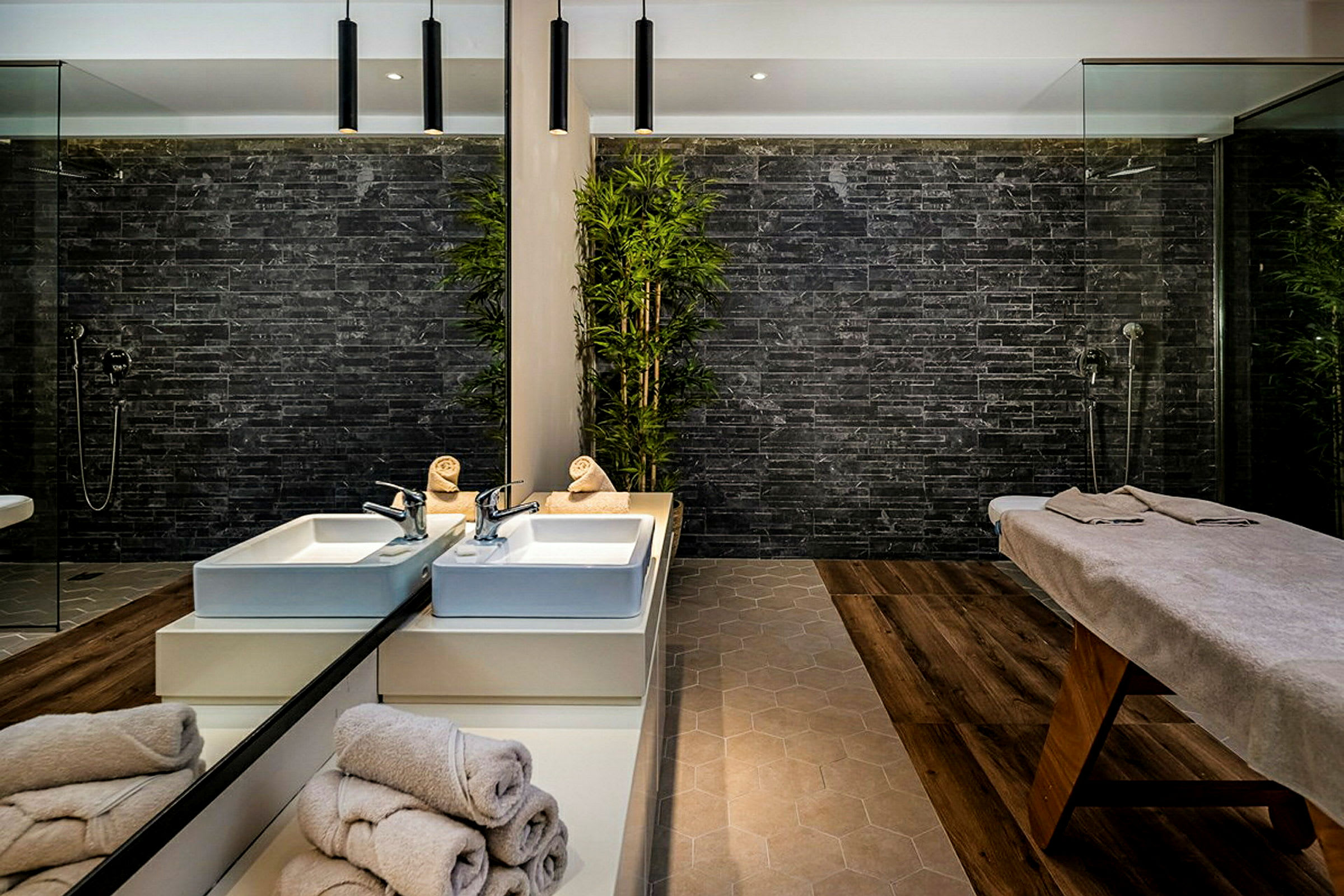 Et moderne spa-område med en behandlingsseng og to vaskebassiner. (AI-genereret tekst)
