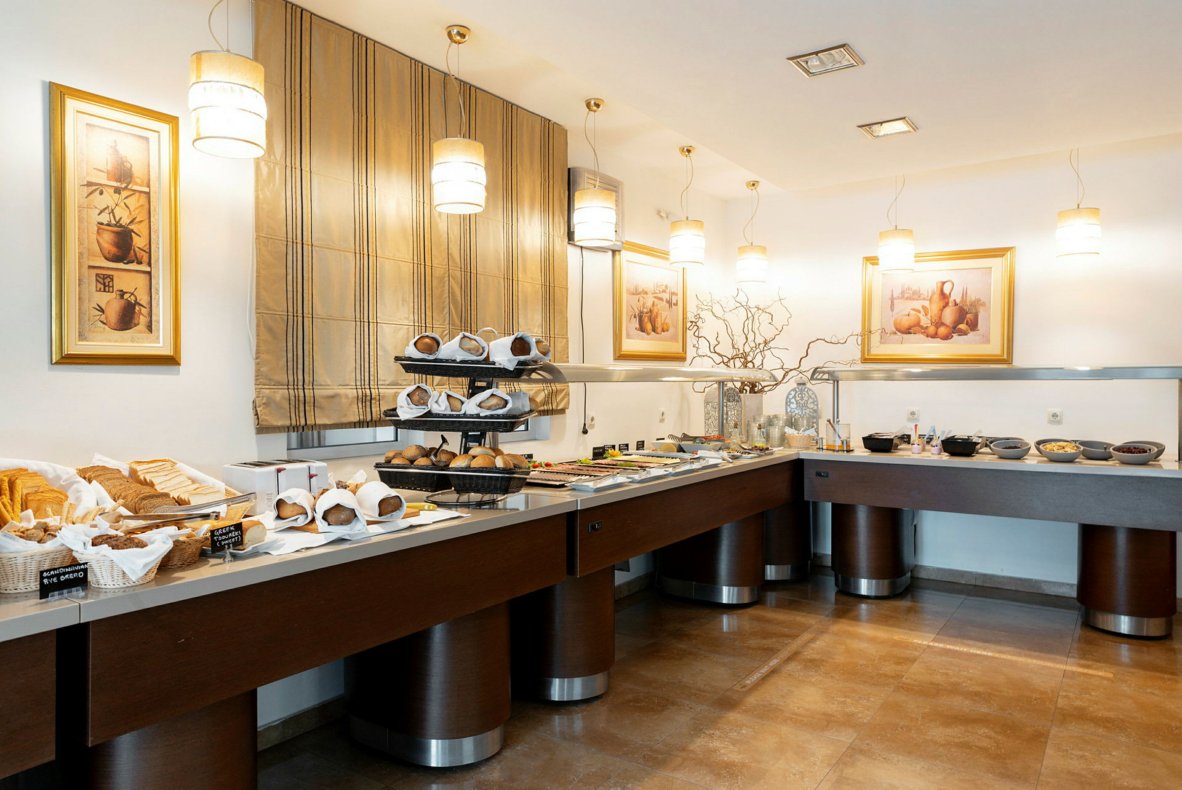 En buffet med forskellige madretter og brød. Kunst på væggene og behagelig belysning. (AI-genereret tekst)