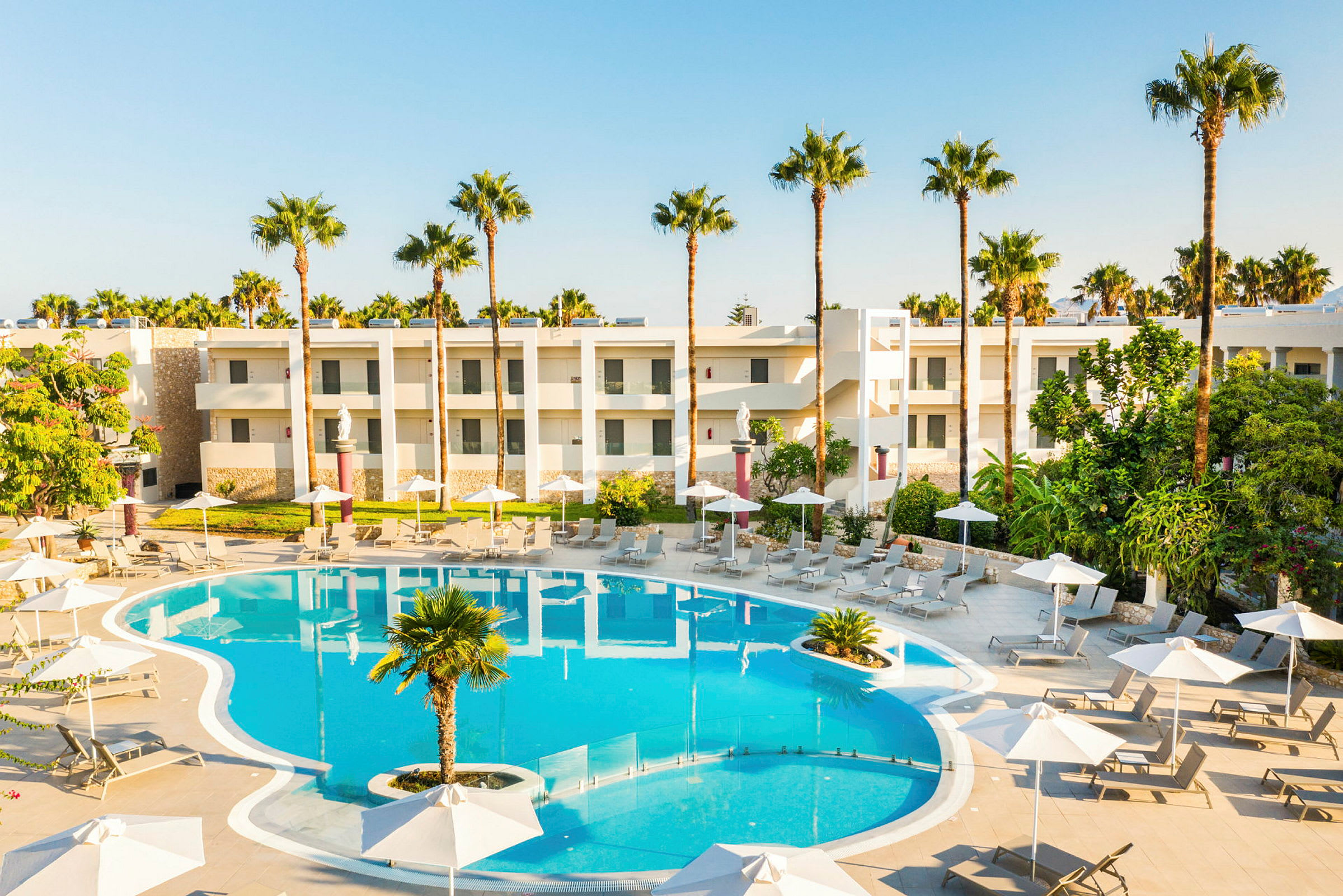 Poolområde med solsenge, parasoller og hotelbygninger i baggrunden. (AI-genereret tekst)