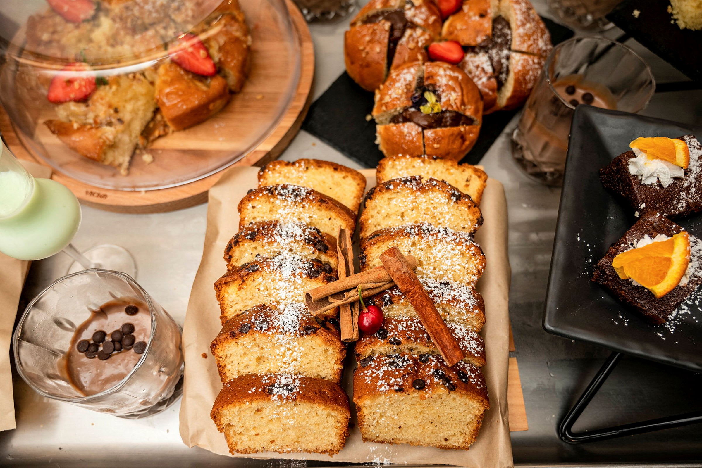 Assorterede bagværk, herunder skiveskåret kage, muffins og brownies med pynt. (AI-genereret tekst)