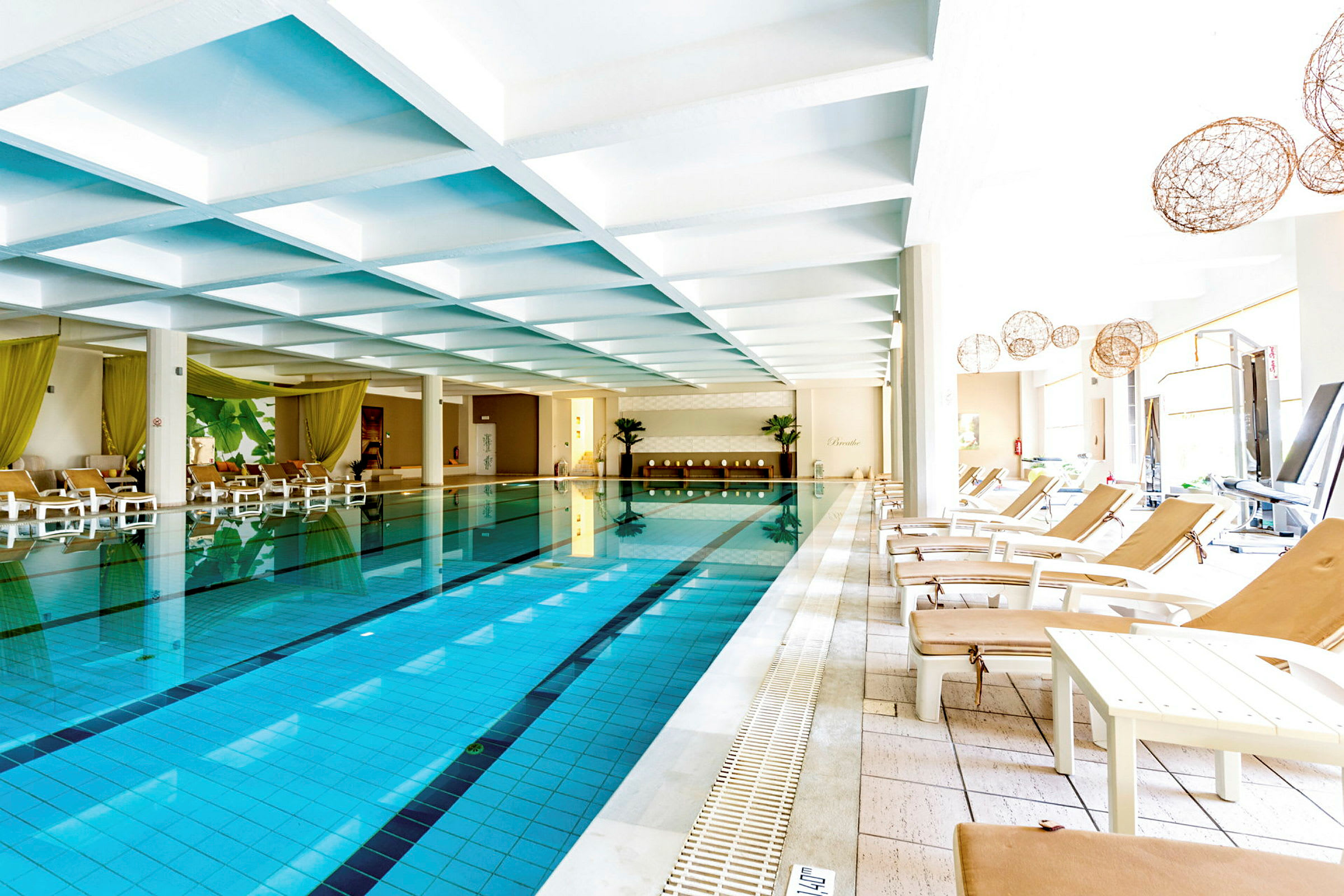 Indendørs pool med solsenge langs kanten. (AI-genereret tekst)