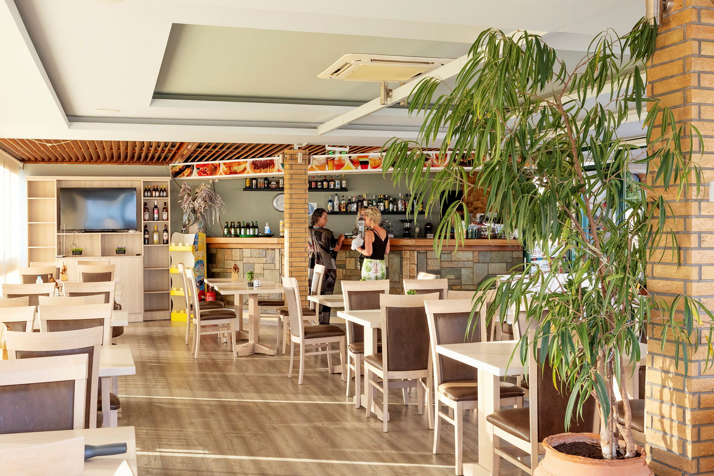 Restaurant med borde, stole og en bardisk. (AI-genereret tekst)