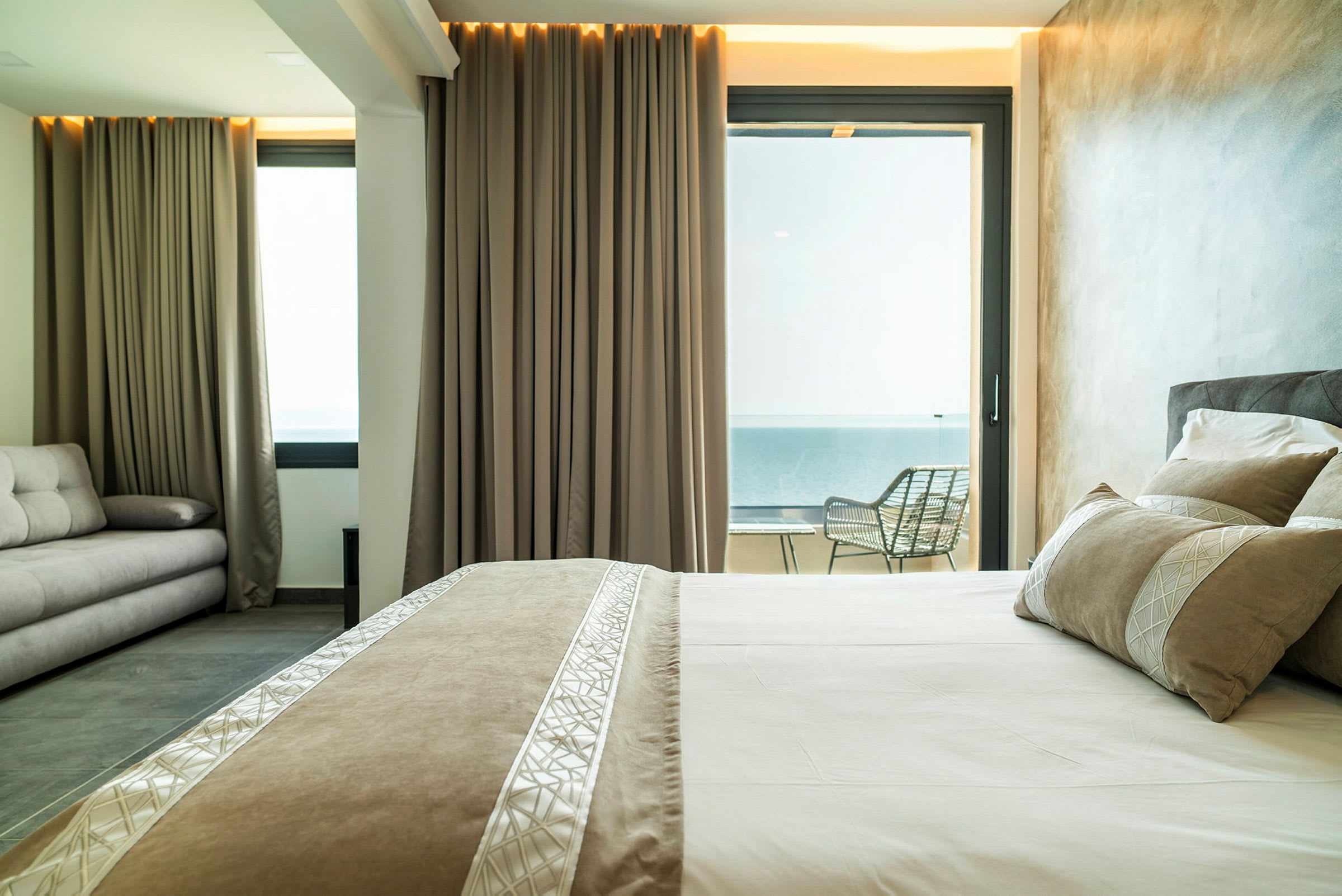 Hotelværelse med seng, sofa og altan. (AI-genereret tekst)