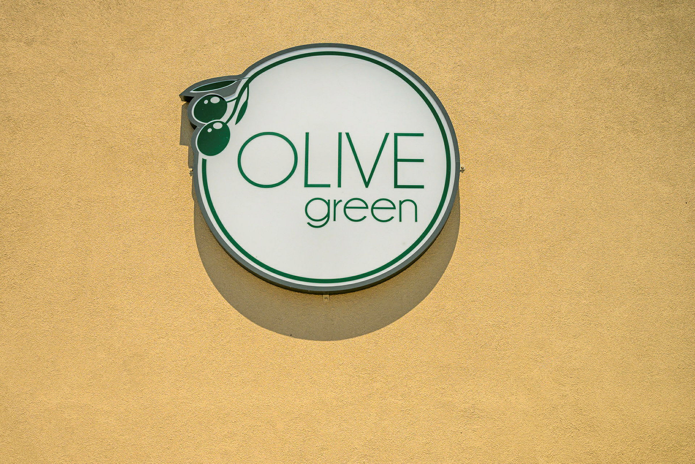 Skilt med teksten 'Olive Green' på gul baggrund. (AI-genereret tekst)