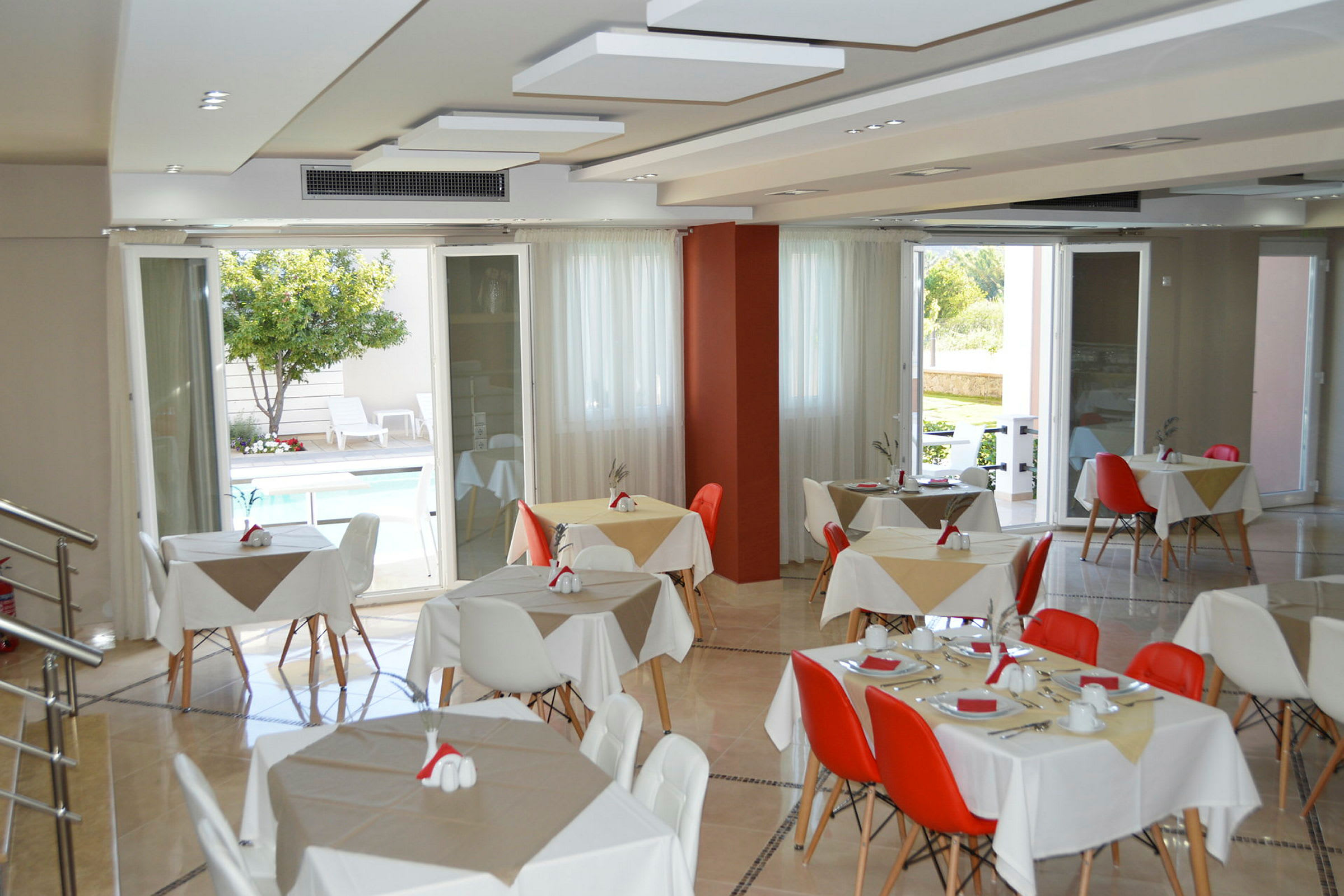 Restaurant med opdugede borde og udsigt til en udendørs pool. (AI-genereret tekst)