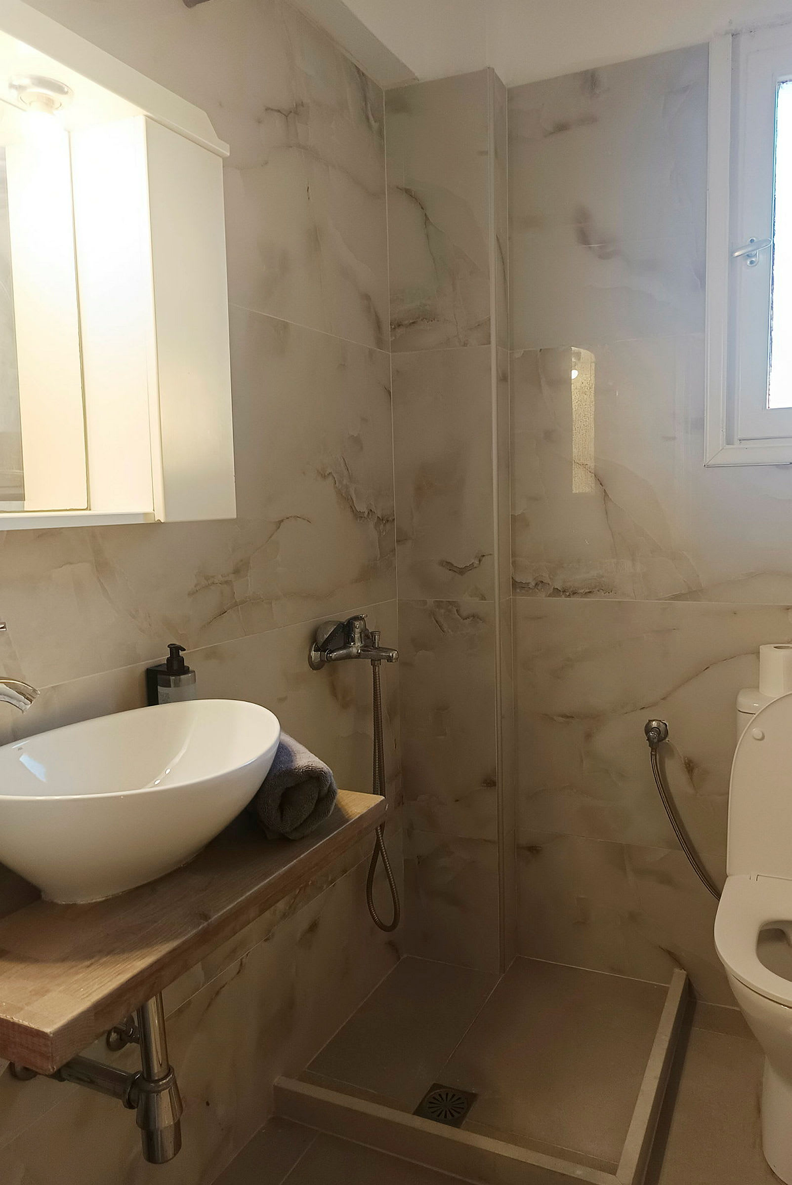 Moderne badeværelse med håndvask, bruser og toilet. (AI-genereret tekst)