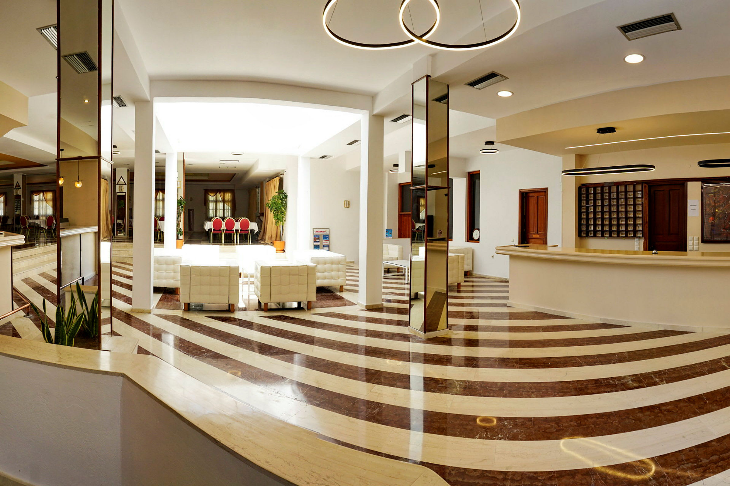 Moderne hotellobby med receptionsområde og siddepladser. (AI-genereret tekst)