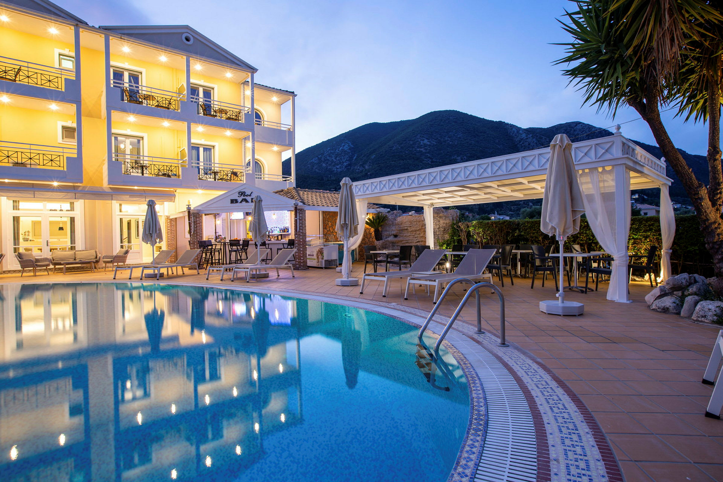 Hotellets facade med pool og liggestole i forgrunden. (AI-genereret tekst)