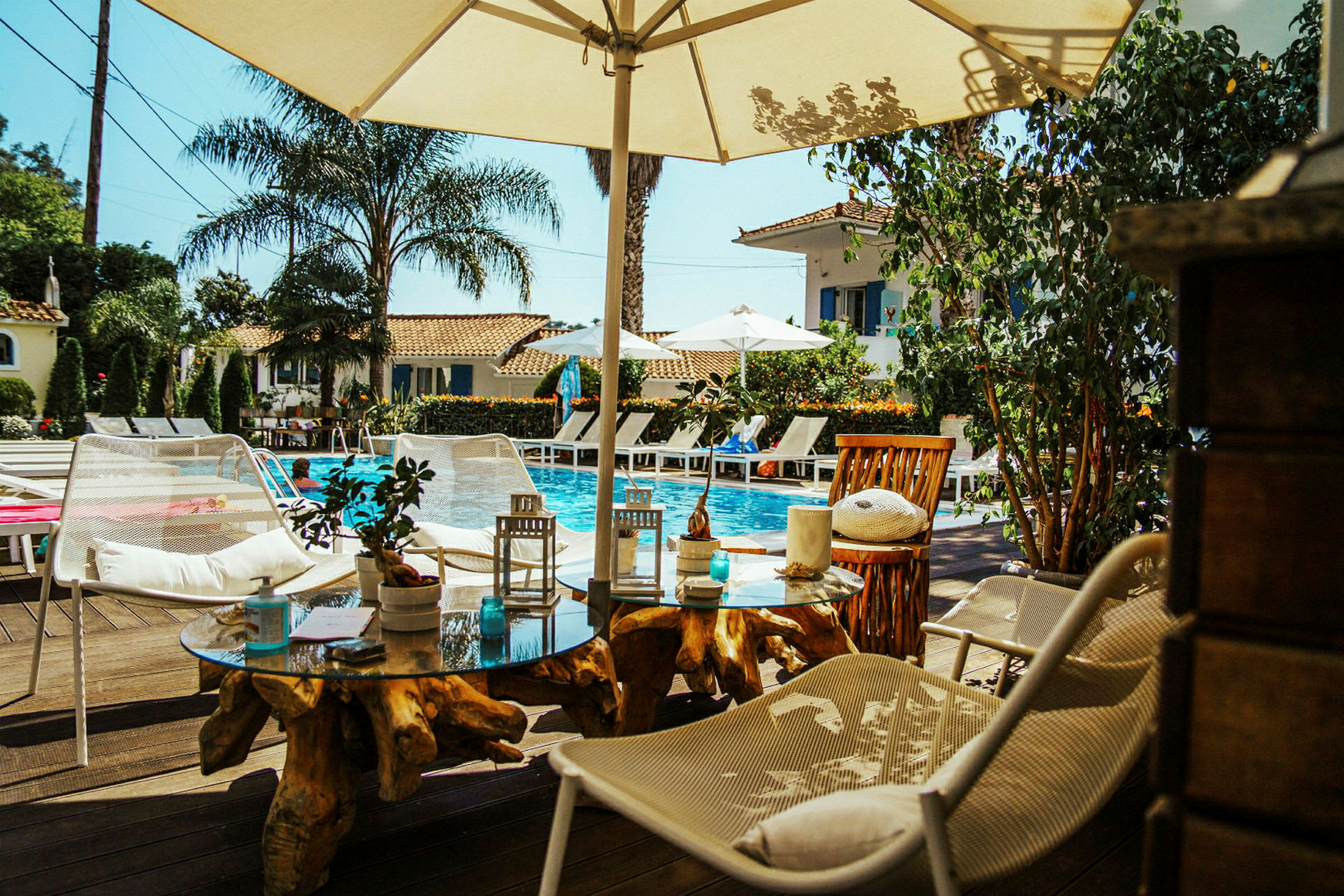 En pool med liggestole og parasoller i et solrigt hotelområde. (AI-genereret tekst)