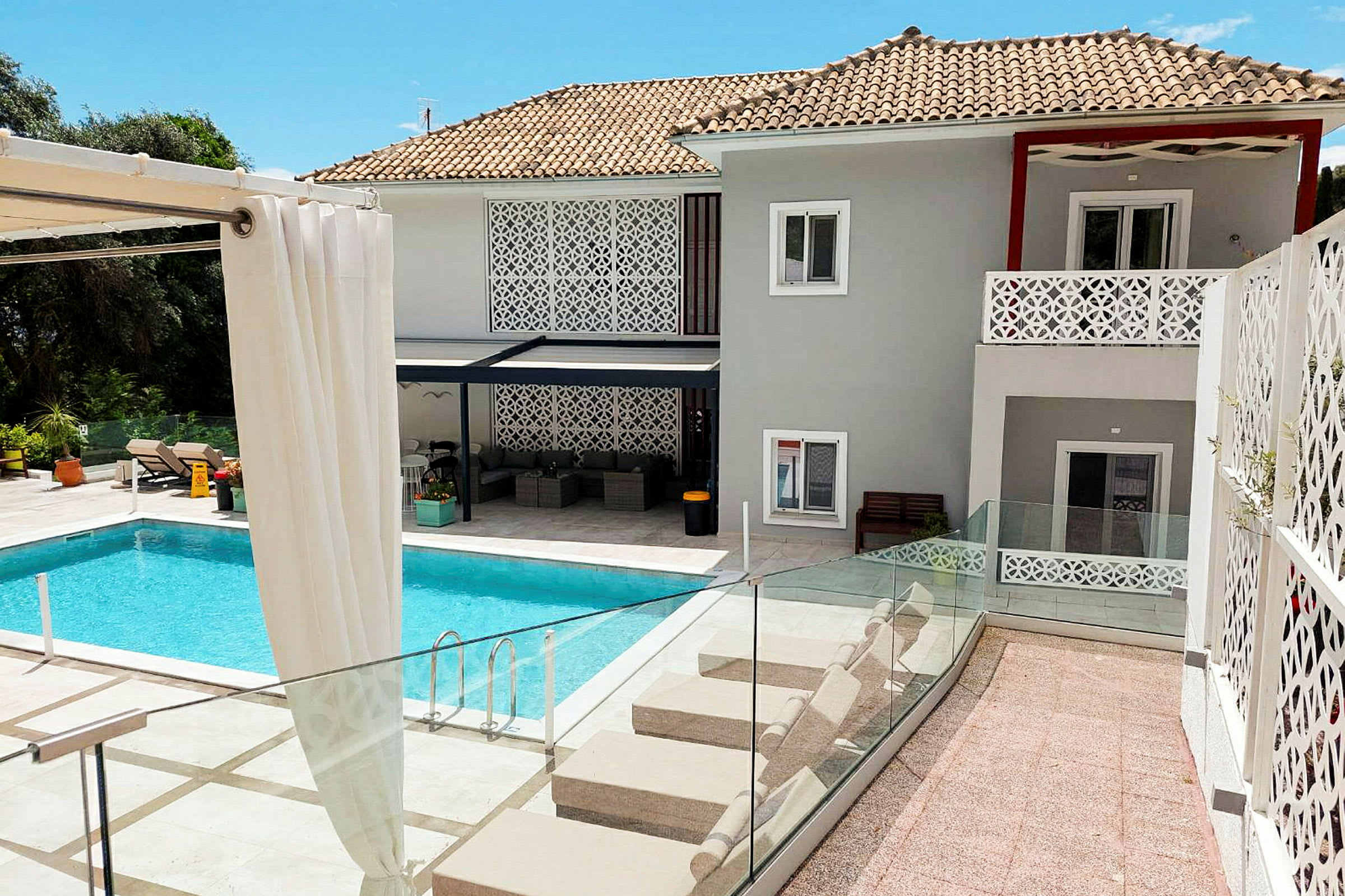 En moderne villa med swimmingpool og liggestole. (AI-genereret tekst)