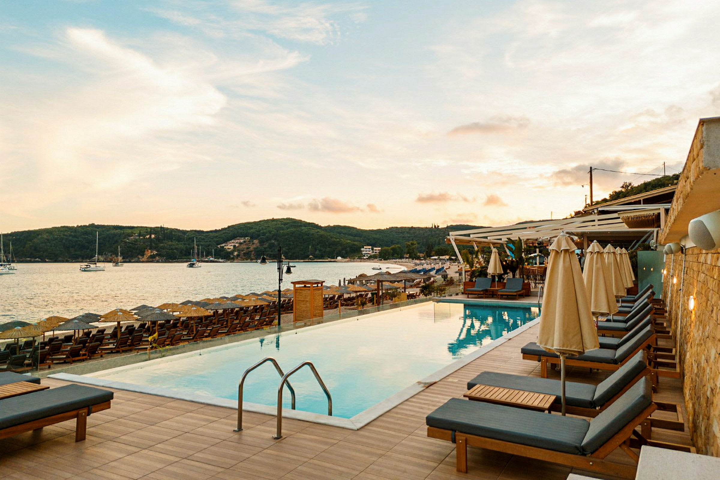 Pool med liggestole ved stranden med havudsigt. (AI-genereret tekst)