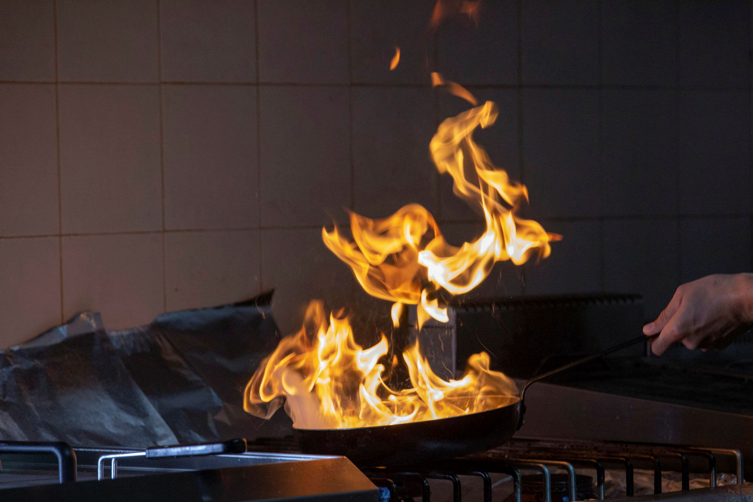 Flammer fra en stegepande på en komfur. (AI-genereret tekst)