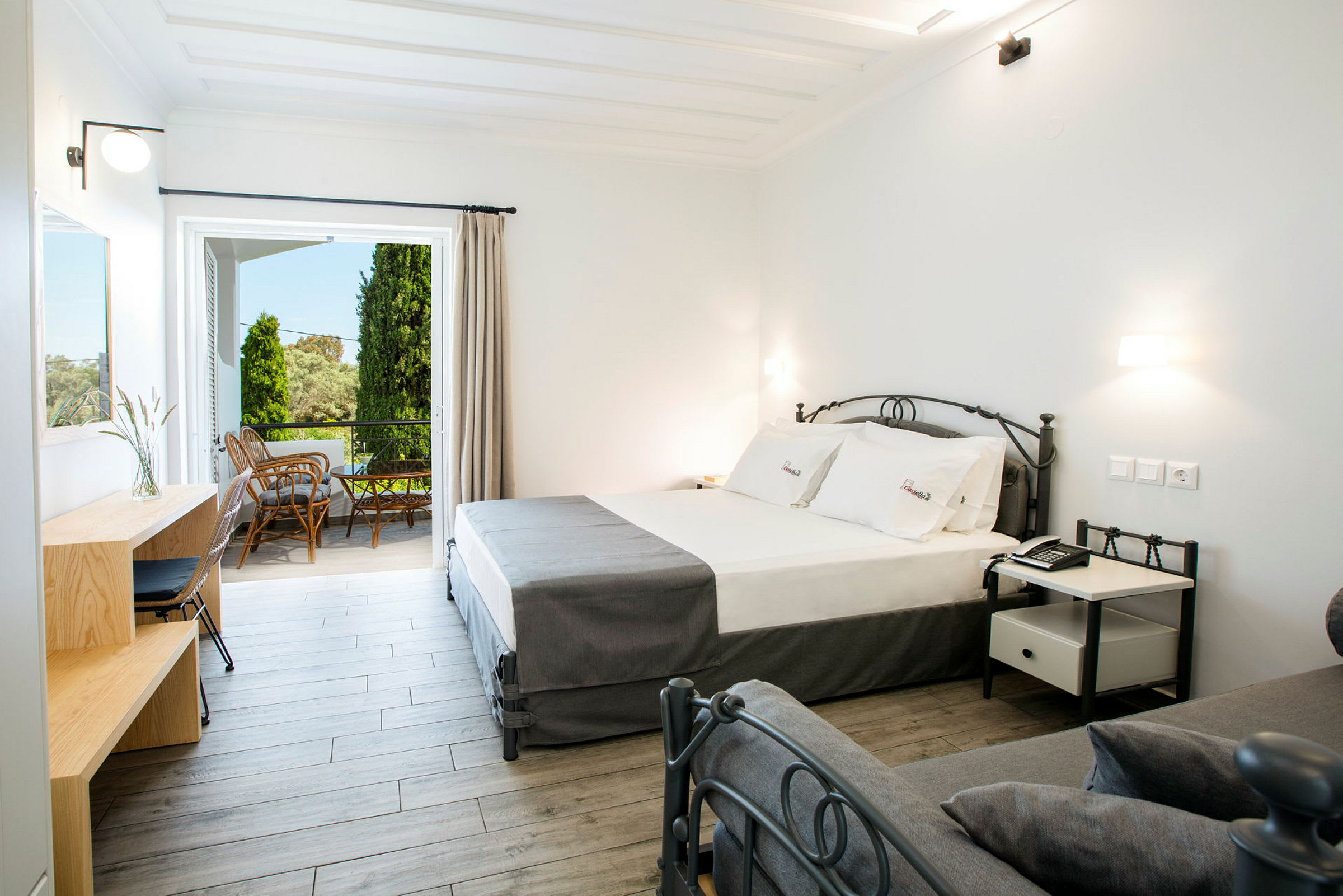 Moderne hotelværelse med seng, skrivebord og adgang til møbleret altan. (AI-genereret tekst)