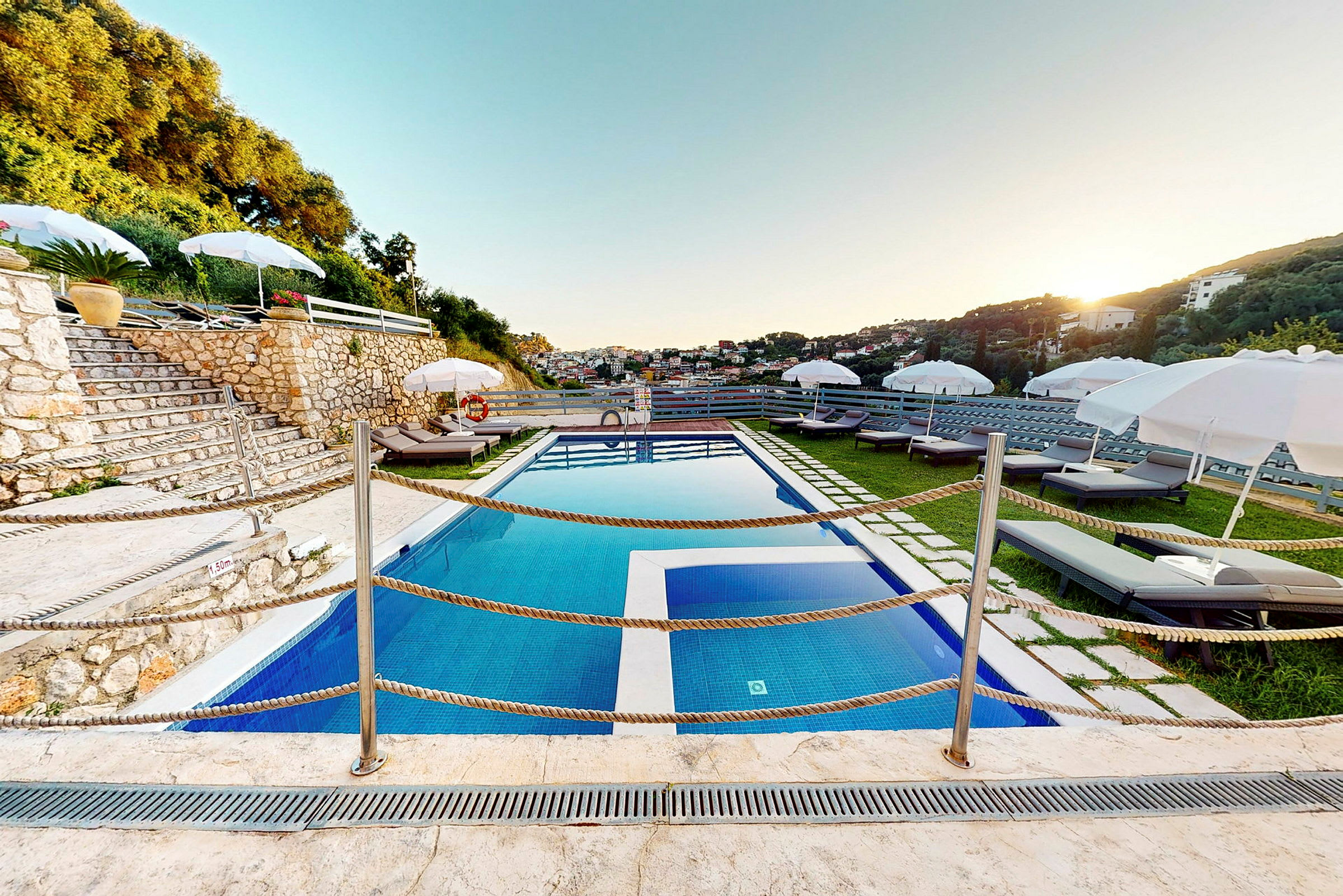 Udendørs pool med liggestole og parasoller på en terrasse. (AI-genereret tekst)