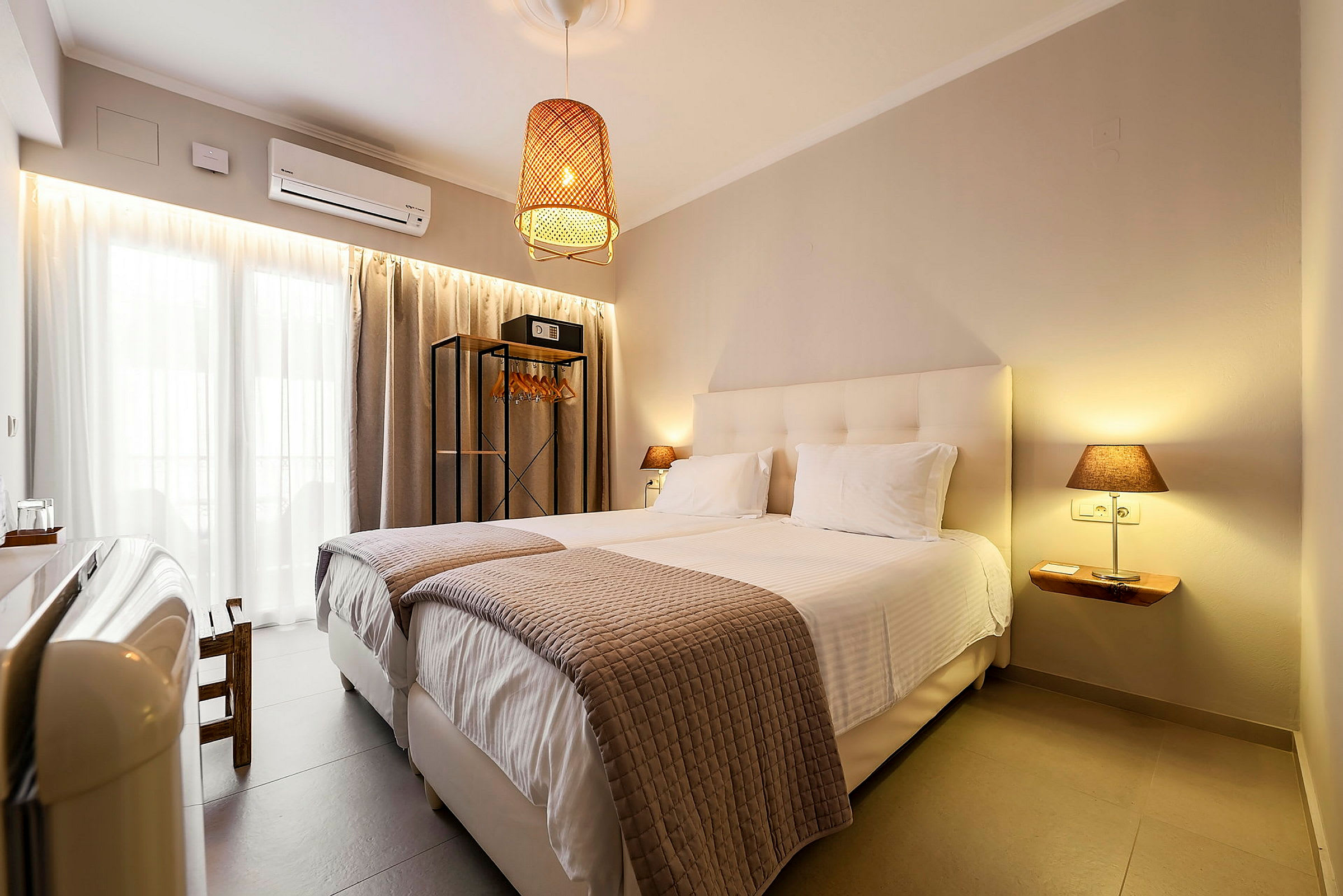 Et hotelværelse med to enkeltsenge, moderne indretning og en hængende lampe. (AI-genereret tekst)