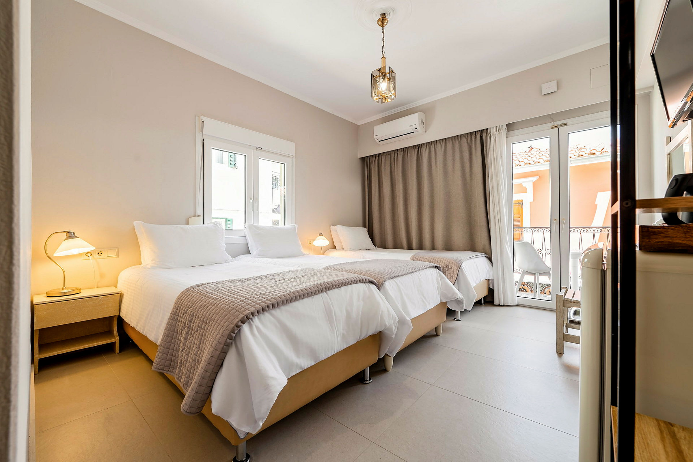Interiør af et hotelværelse med tre senge, lamper og vinduer. (AI-genereret tekst)