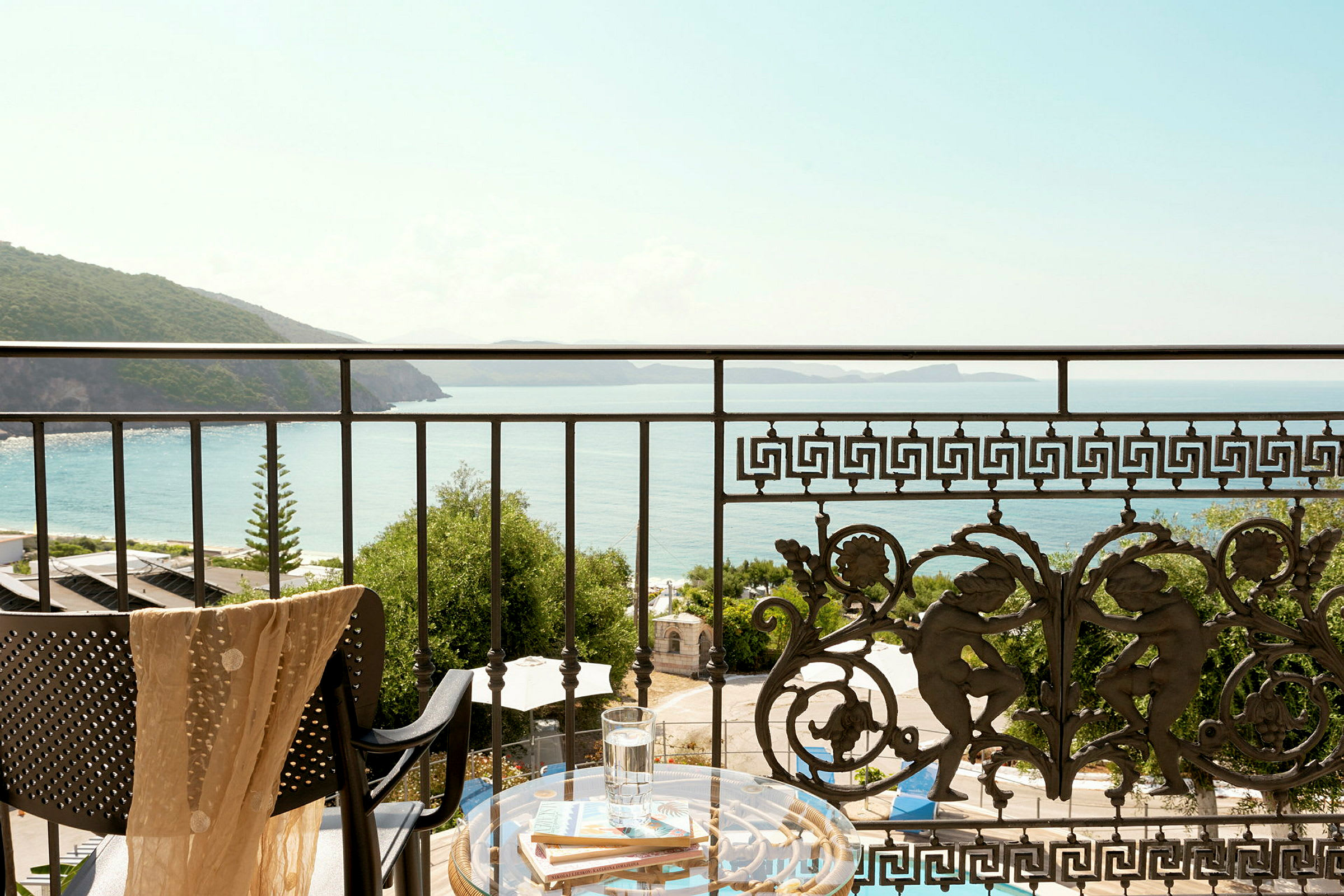Udsigt fra en balkon med dekorativt rækværk over havet og kysten. (AI-genereret tekst)