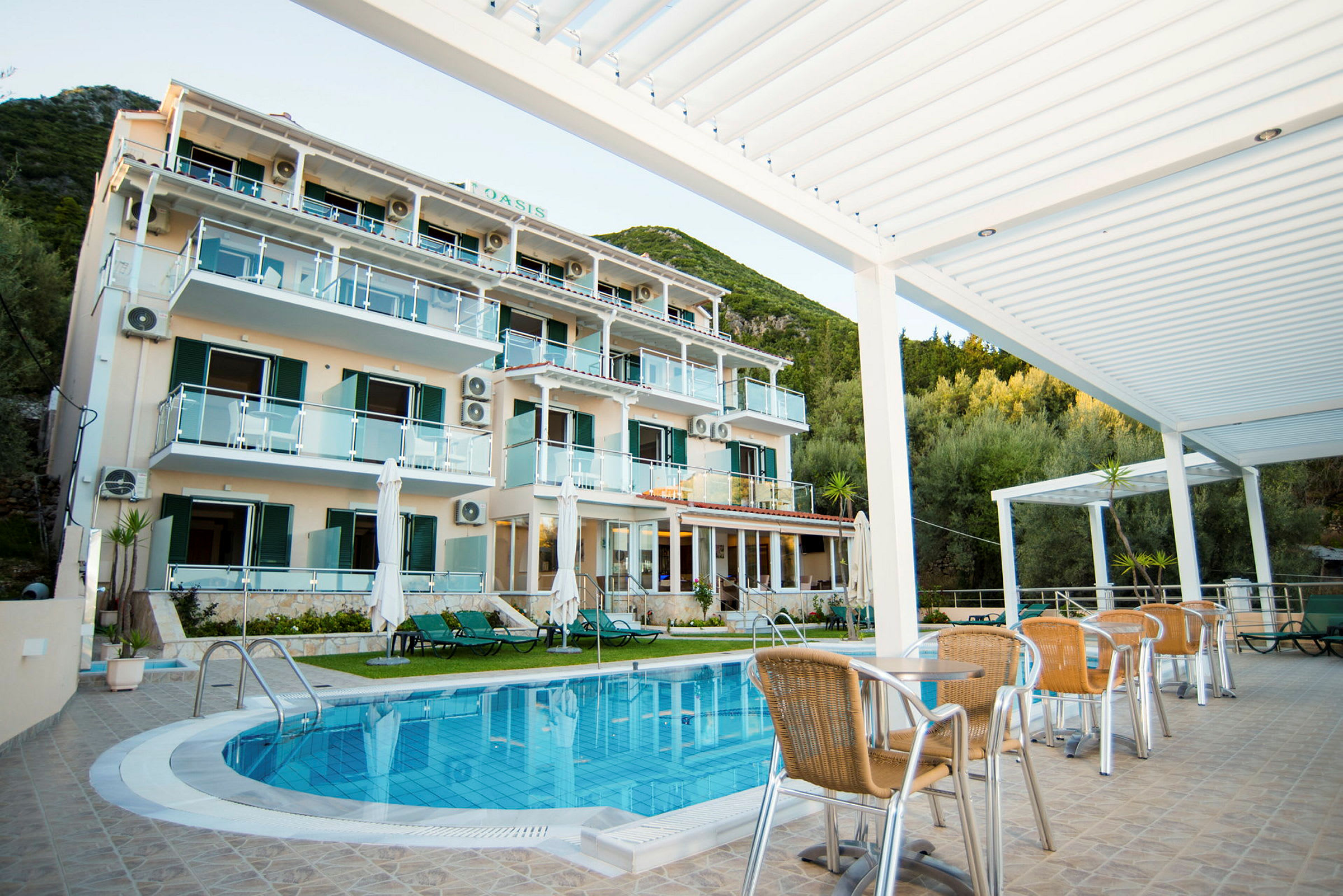 Et hotel med flere etager foran en pool og havemøbler. (AI-genereret tekst)
